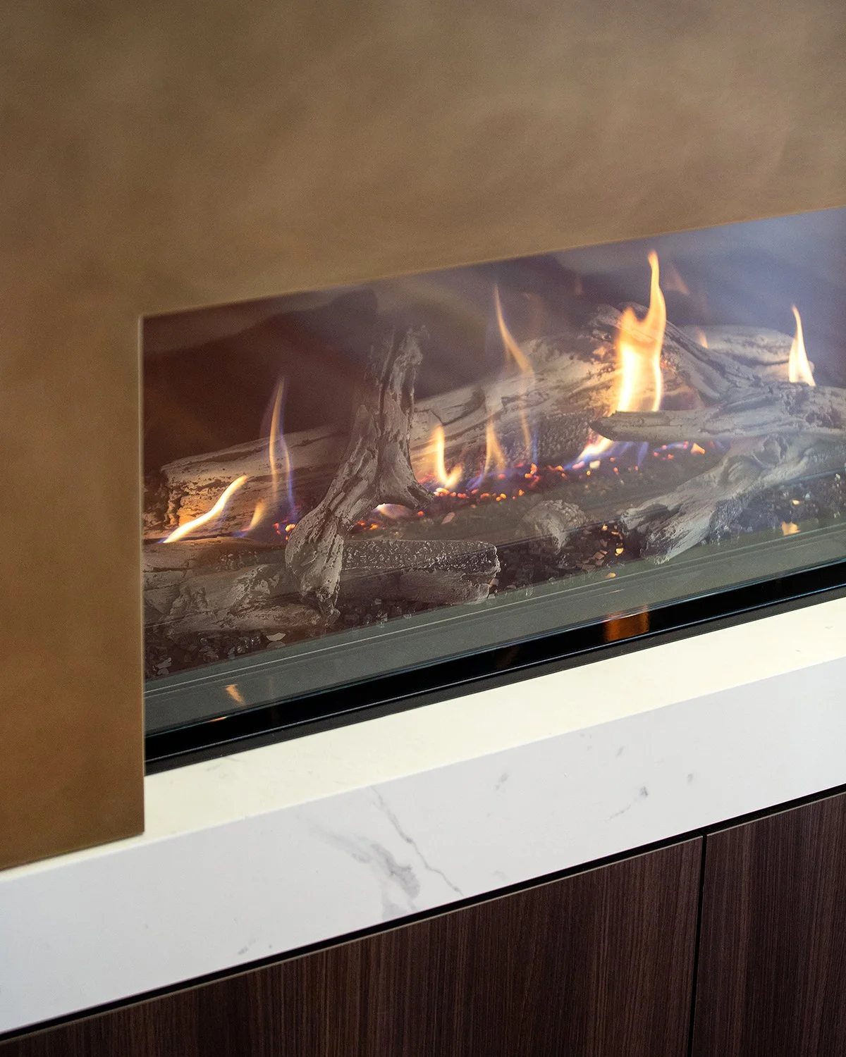Detail of a modern gas fireplace set within custom joinery and stone surround in an Elwood townhouse renovation.