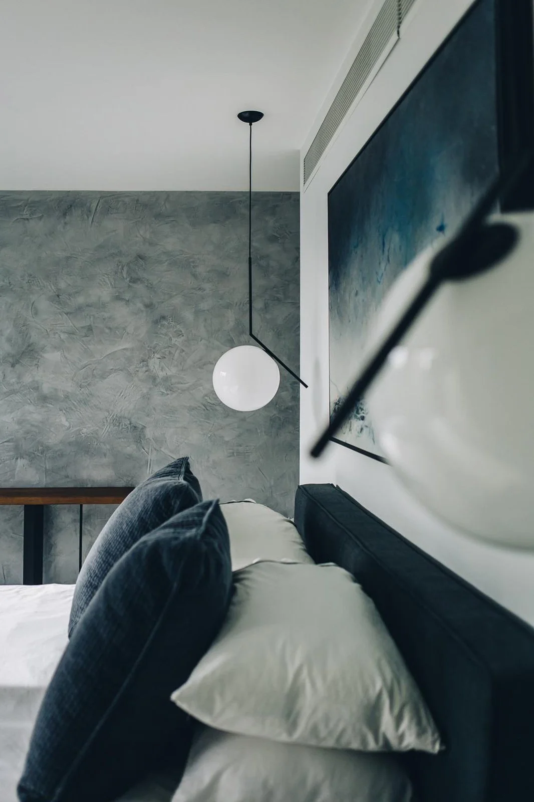 Bedroom with textured grey plaster feature wall with pendant lighting detail