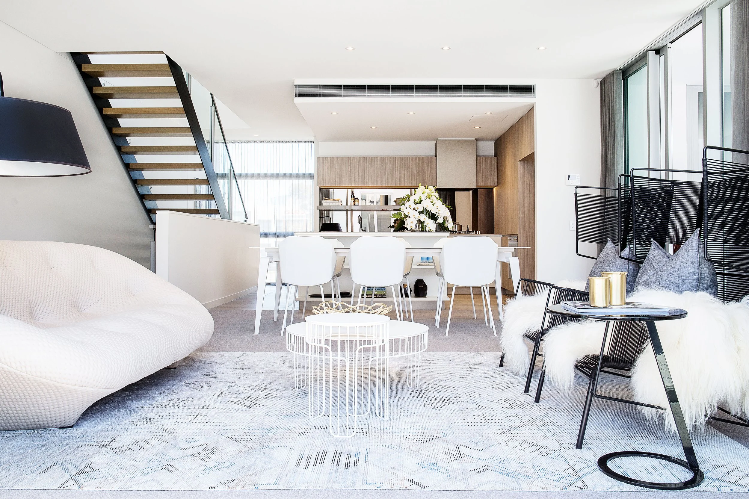 Open plan living and dining area styled for a Mirvac Docklands townhouse with contemporary furniture and soft neutral tones