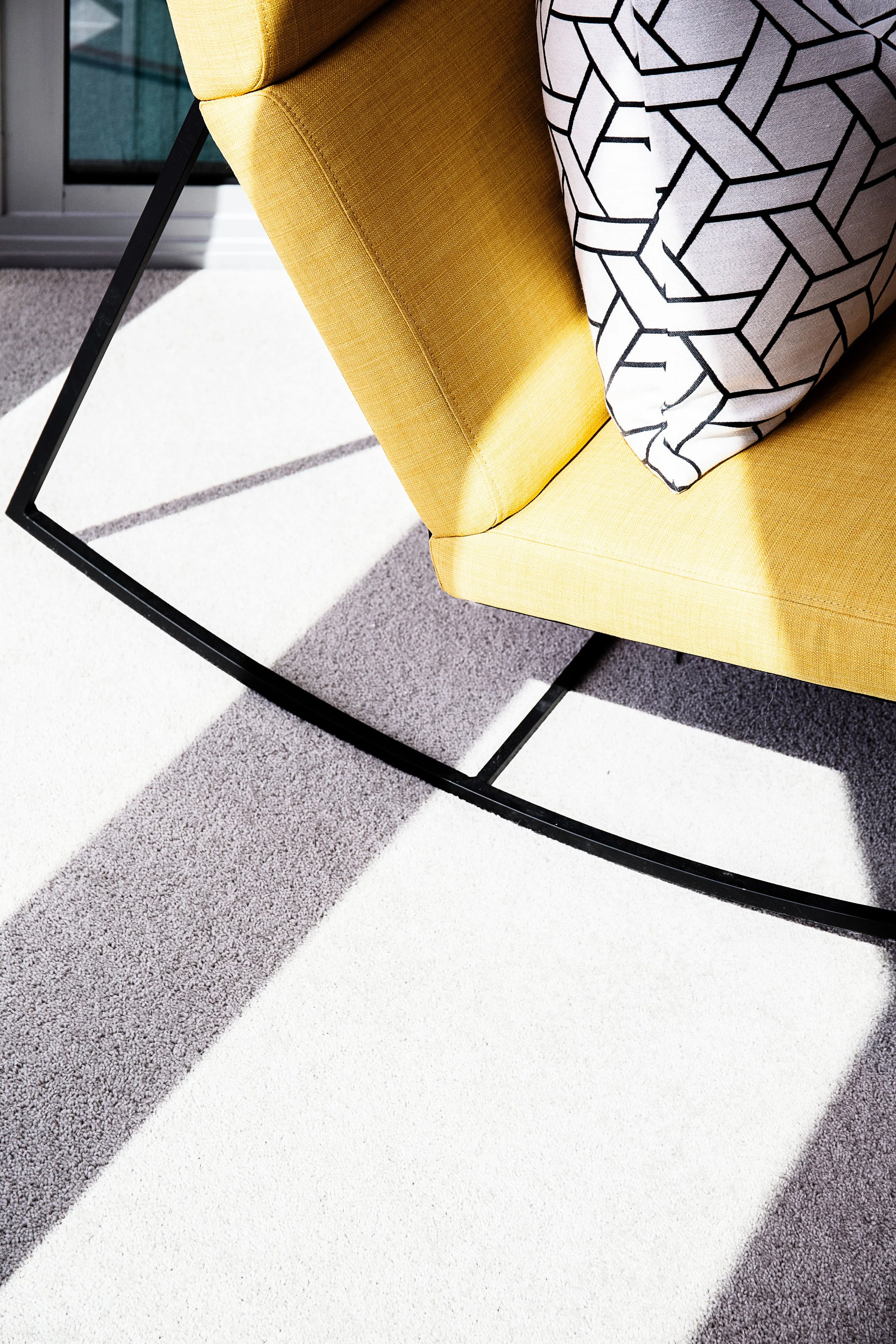 Yellow accent lounge chair in floor to ceiling Docklands apartment with Yarra River views, styled by DMP Creative for Mirvac Forge display suite.