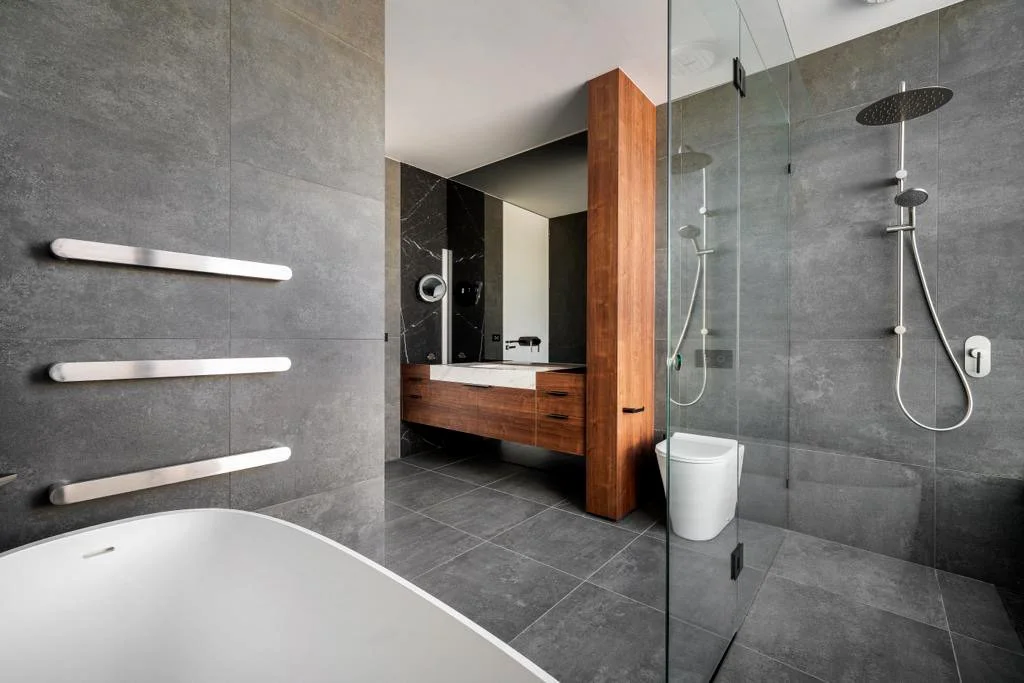 Floating timber vanity with stone top nd free standing bath in modern bathroom