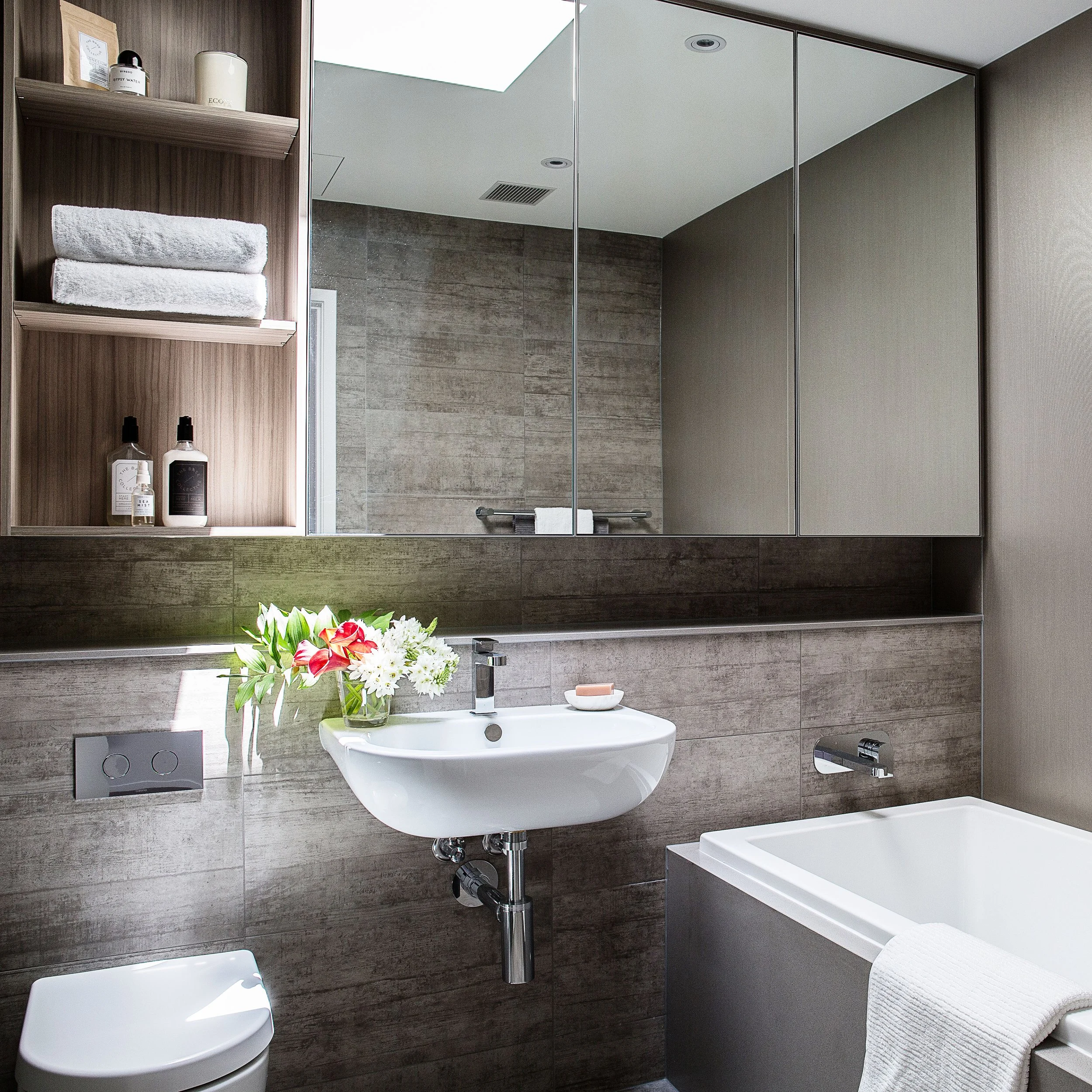 Bathroom vanity styling detail with mirror cabinetry, towels and refined finishes in a Docklands townhouse