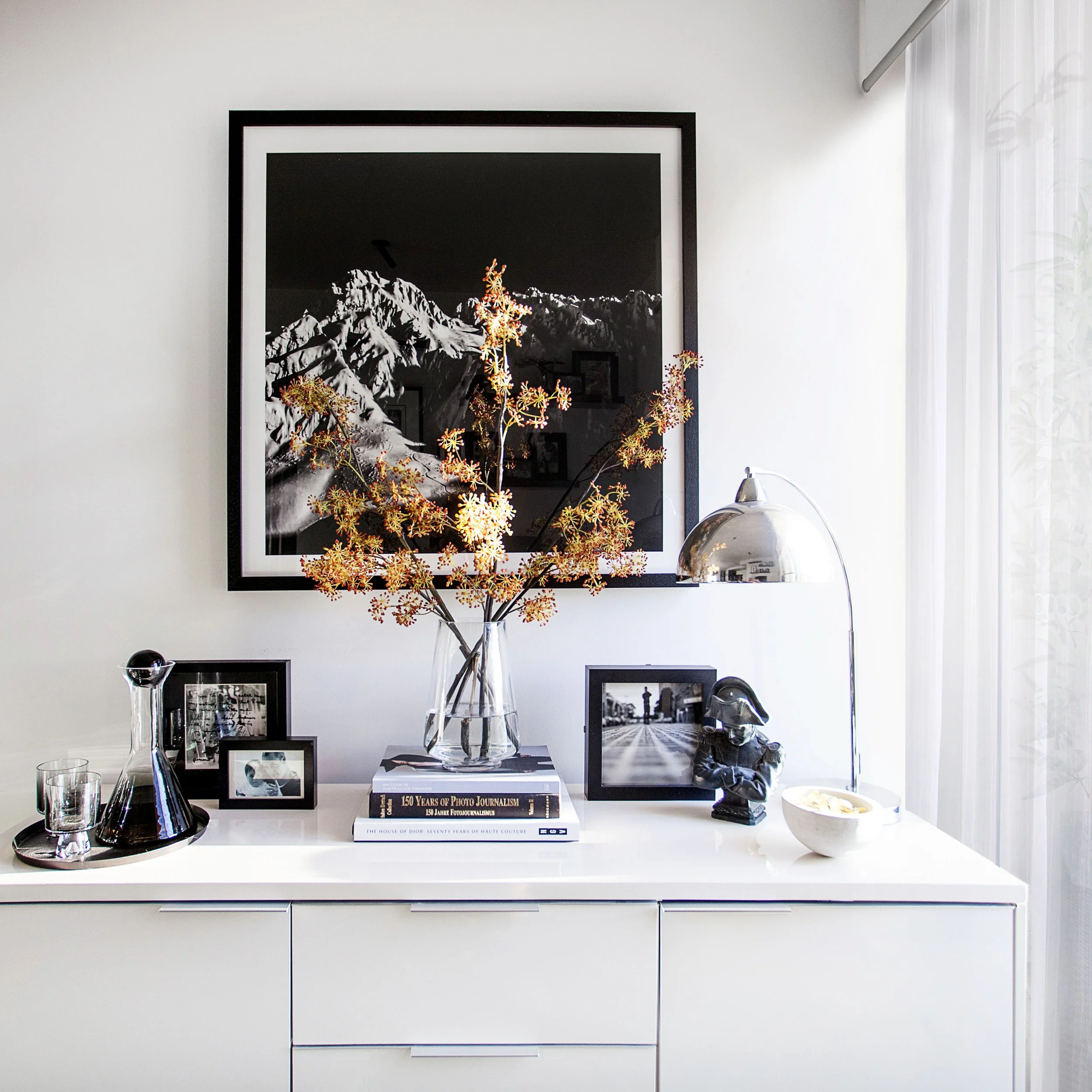 Styled study vignette with desk, chair and decorative objects in modern apartment