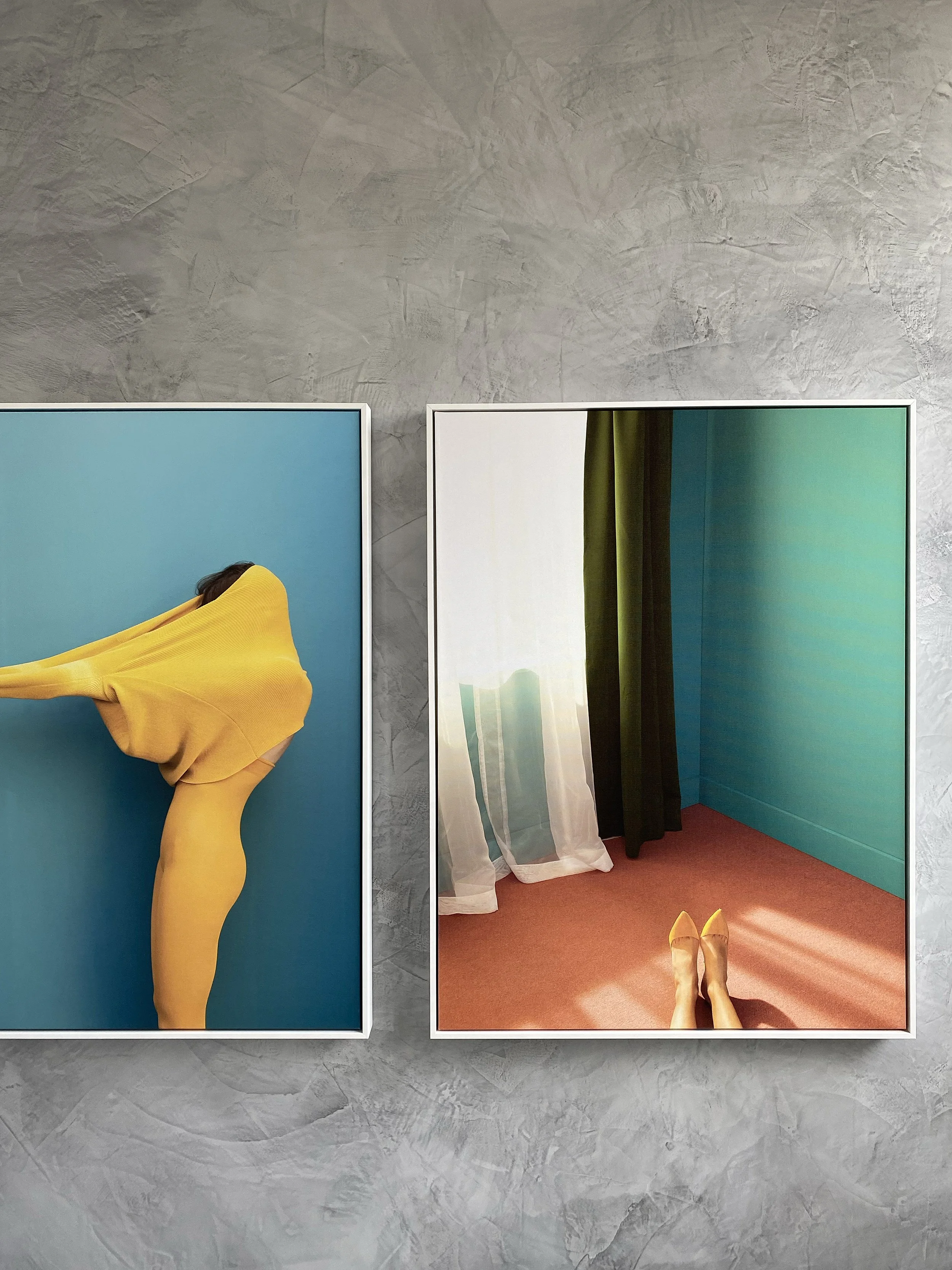 Bedroom with textured grey plaster feature wall and modern photographic artworks