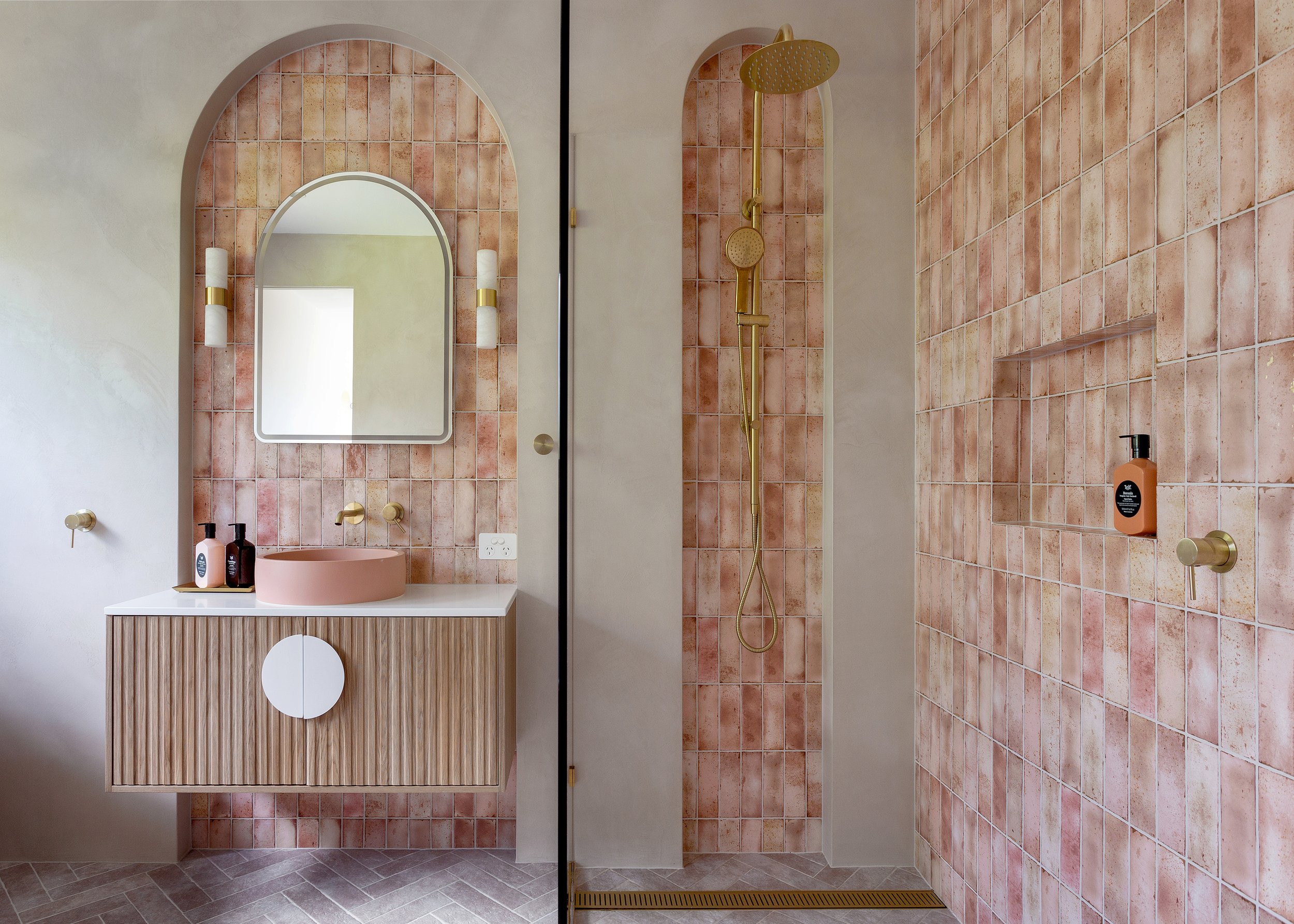 Bathroom at Dromana residence with neutral tiles, brass shower fittings, timber vanity and herringbone floor tiles