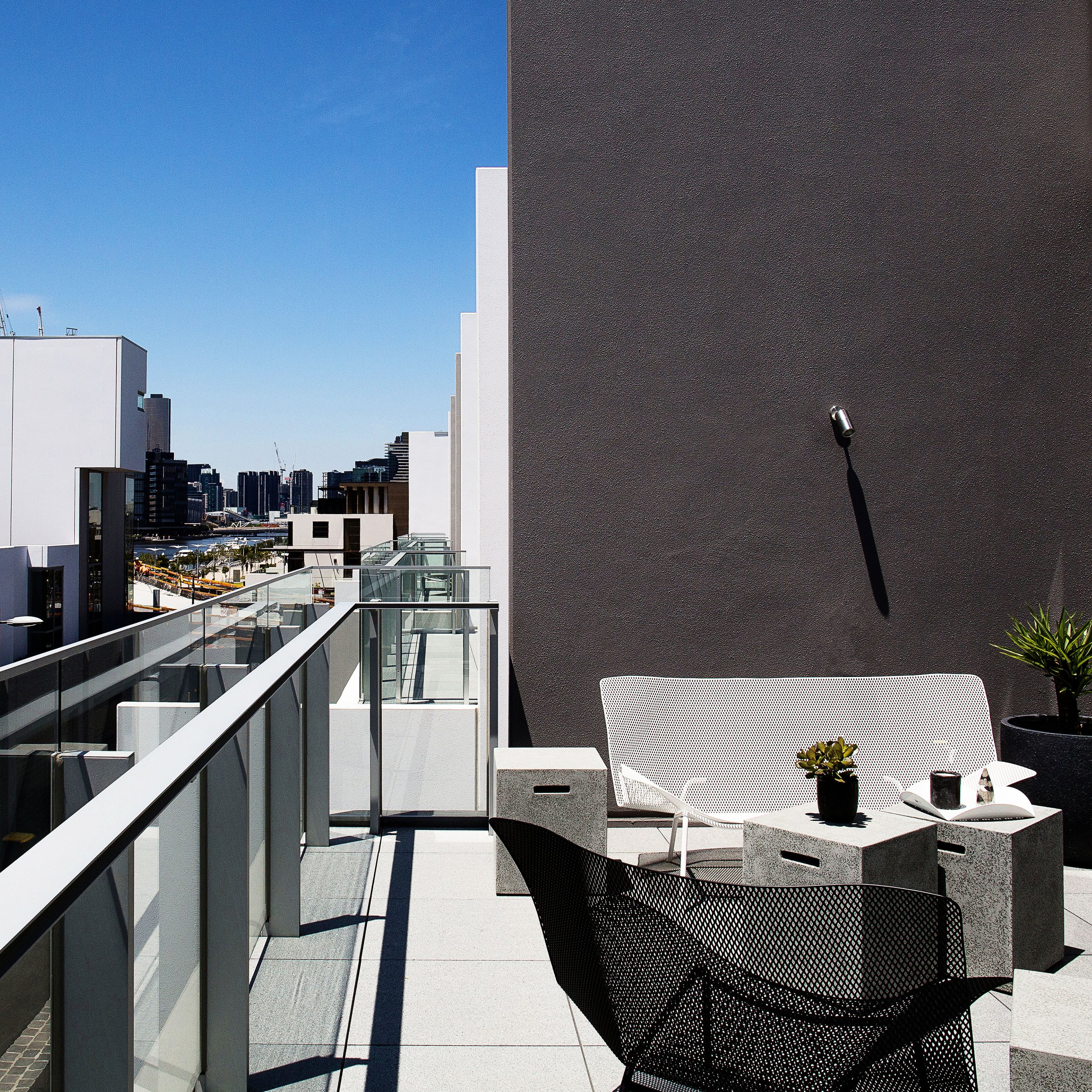 Balcony outdoor lounge styling in a Docklands townhouse with contemporary outdoor furniture and city views