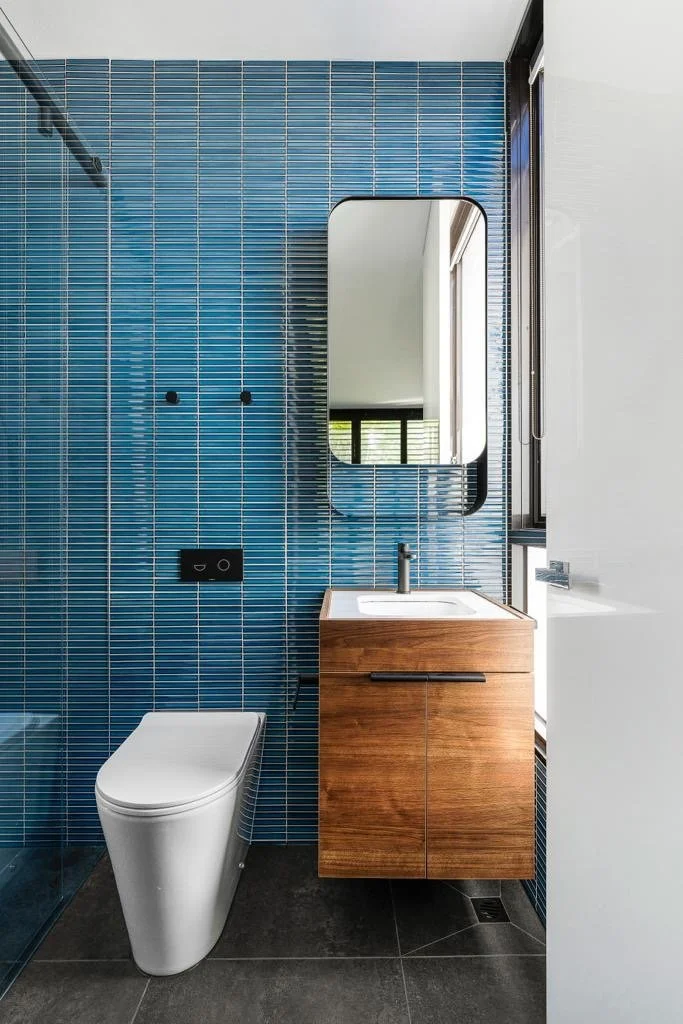 Blue tiled bathroom with timber vanity and contemporary fixtures