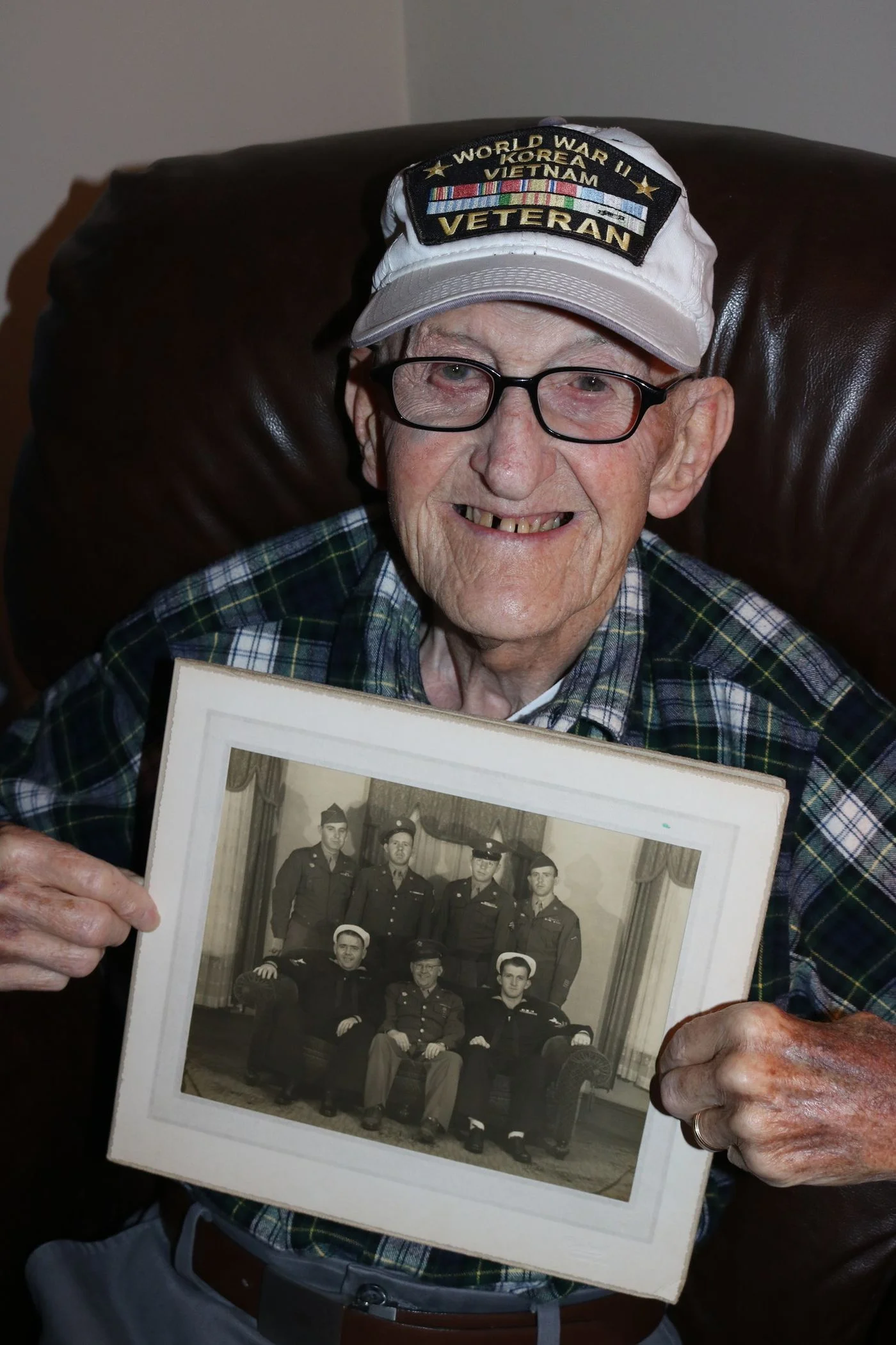 My dad, Andre Lussier, holds a photo of his brothers while wearing his hat