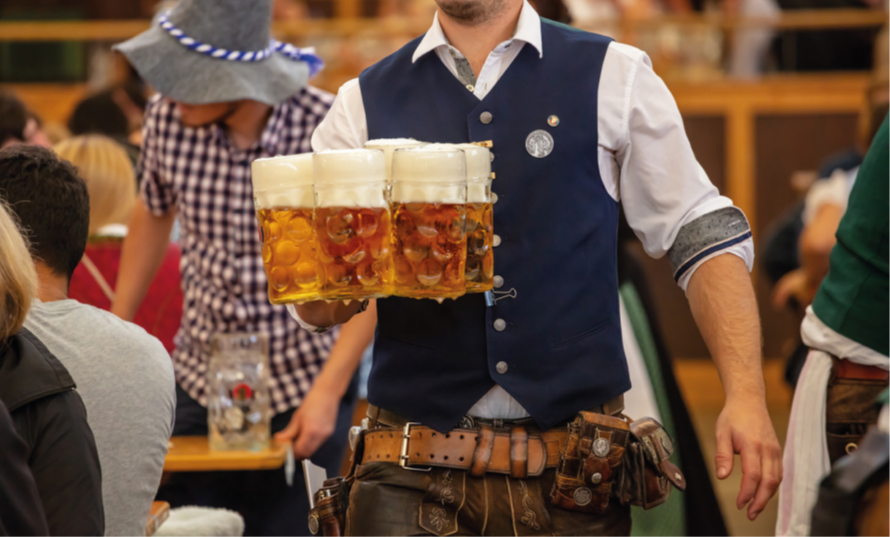 Oktoberfest; Waiter with traditional costume serving beers