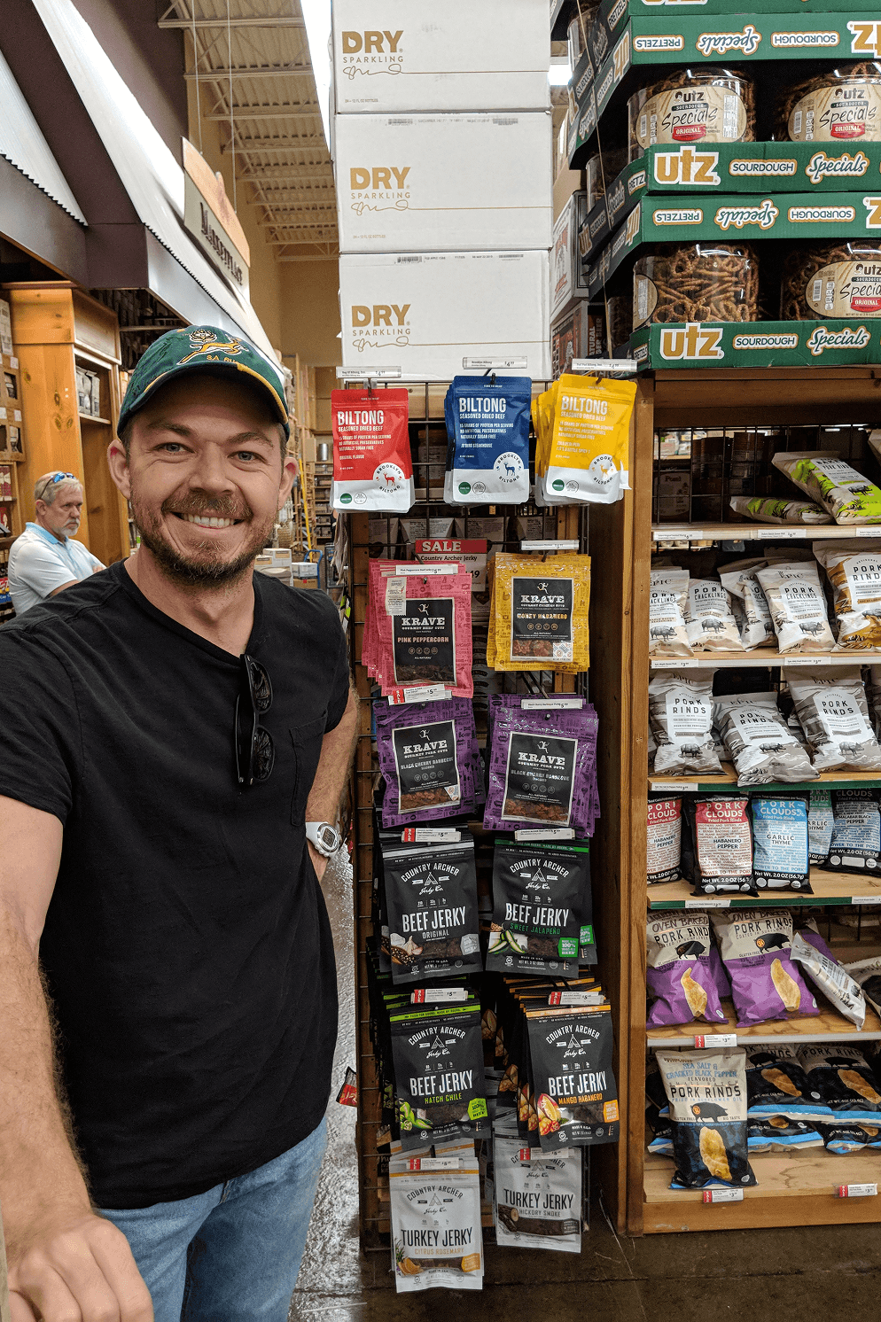 Brooklyn Biltong's red, blue, and yellow packaging displayed among other meat snacks on a grocery store shelf.