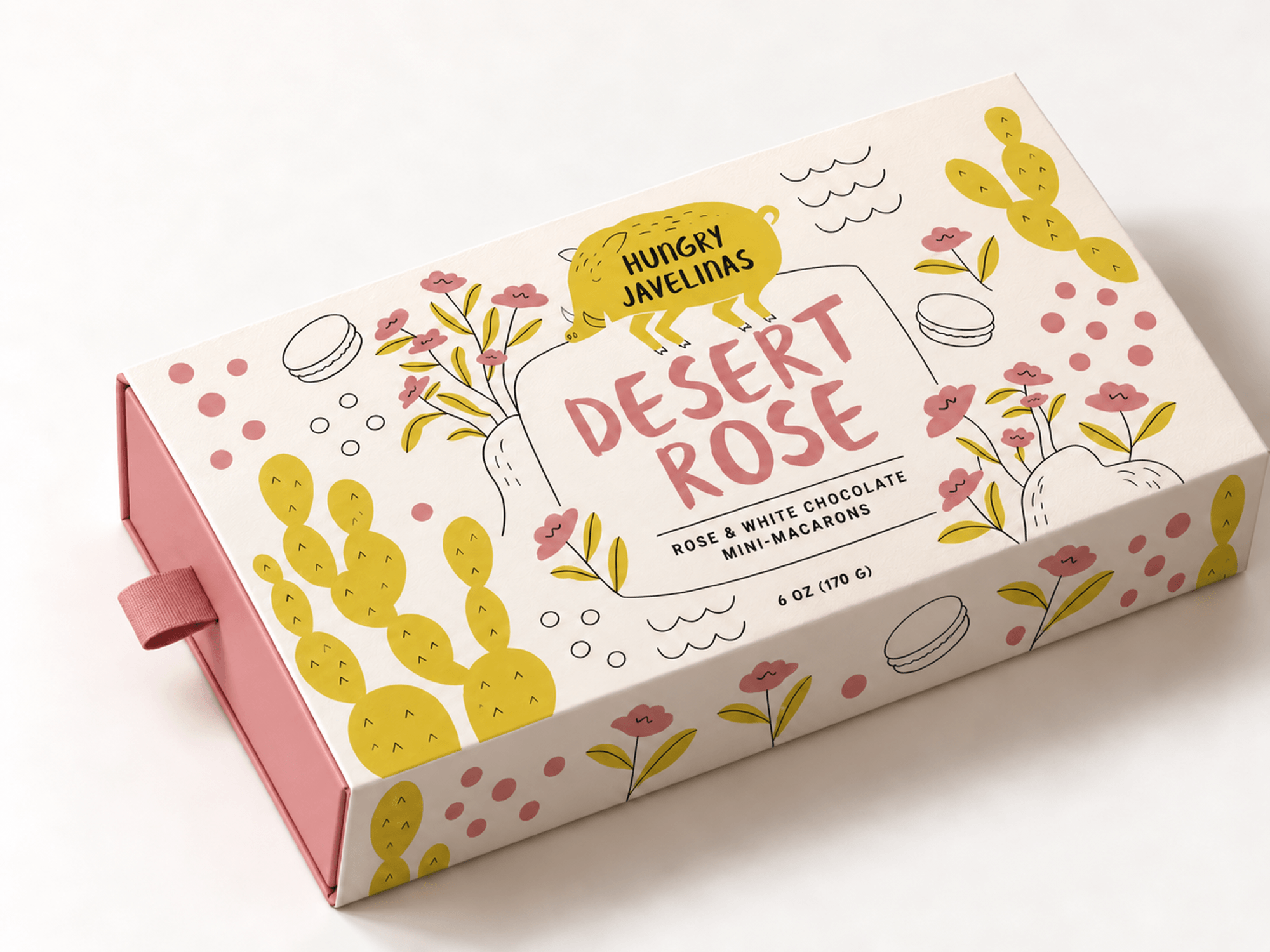Hungry Javelinas Desert Rose mini-macaron box featuring dusty pink typography, illustrated roses, yellow cacti, and a playful javelina logo on cream packaging.