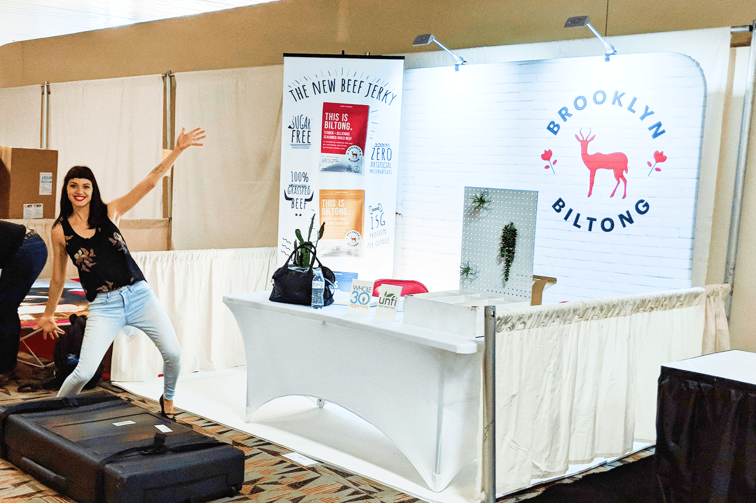 Brooklyn Biltong trade show display featuring branded signage, product information, and a large red antelope logo.