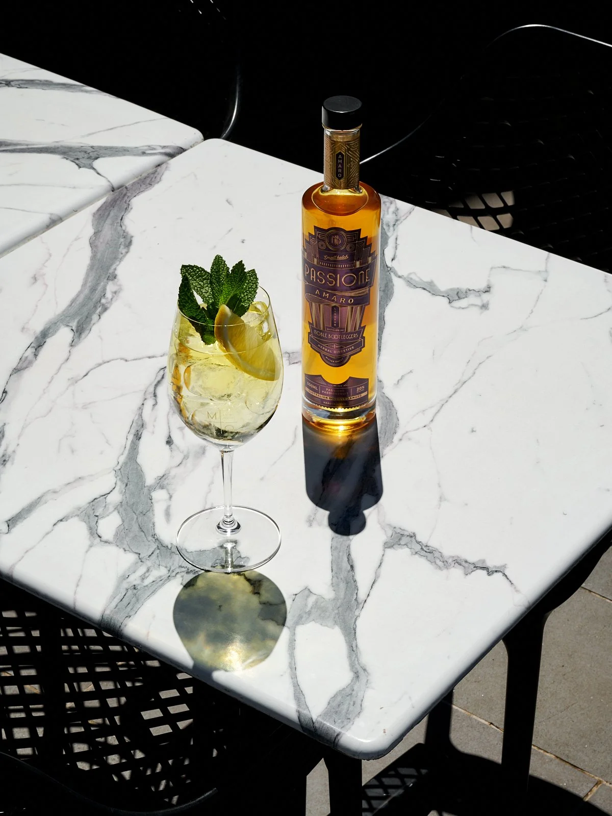 Noble Bootleggers Passione Amaro, accompanied by a Passione Amaro Spritz, garnished with lemon and fresh mint