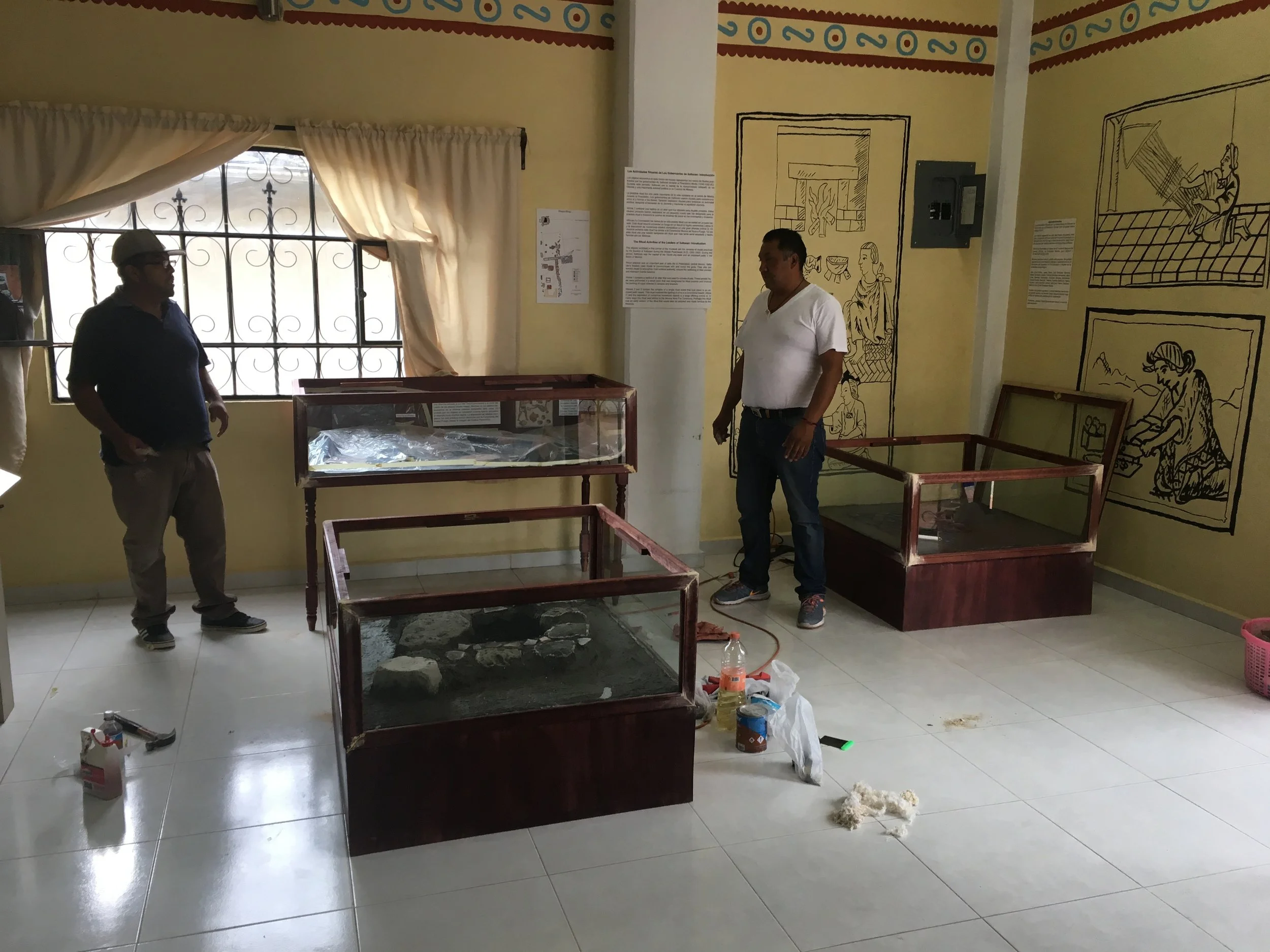 Isidro and Joel make final touches to the vitrines and displays the day before the opening ceremony for the exhibit.