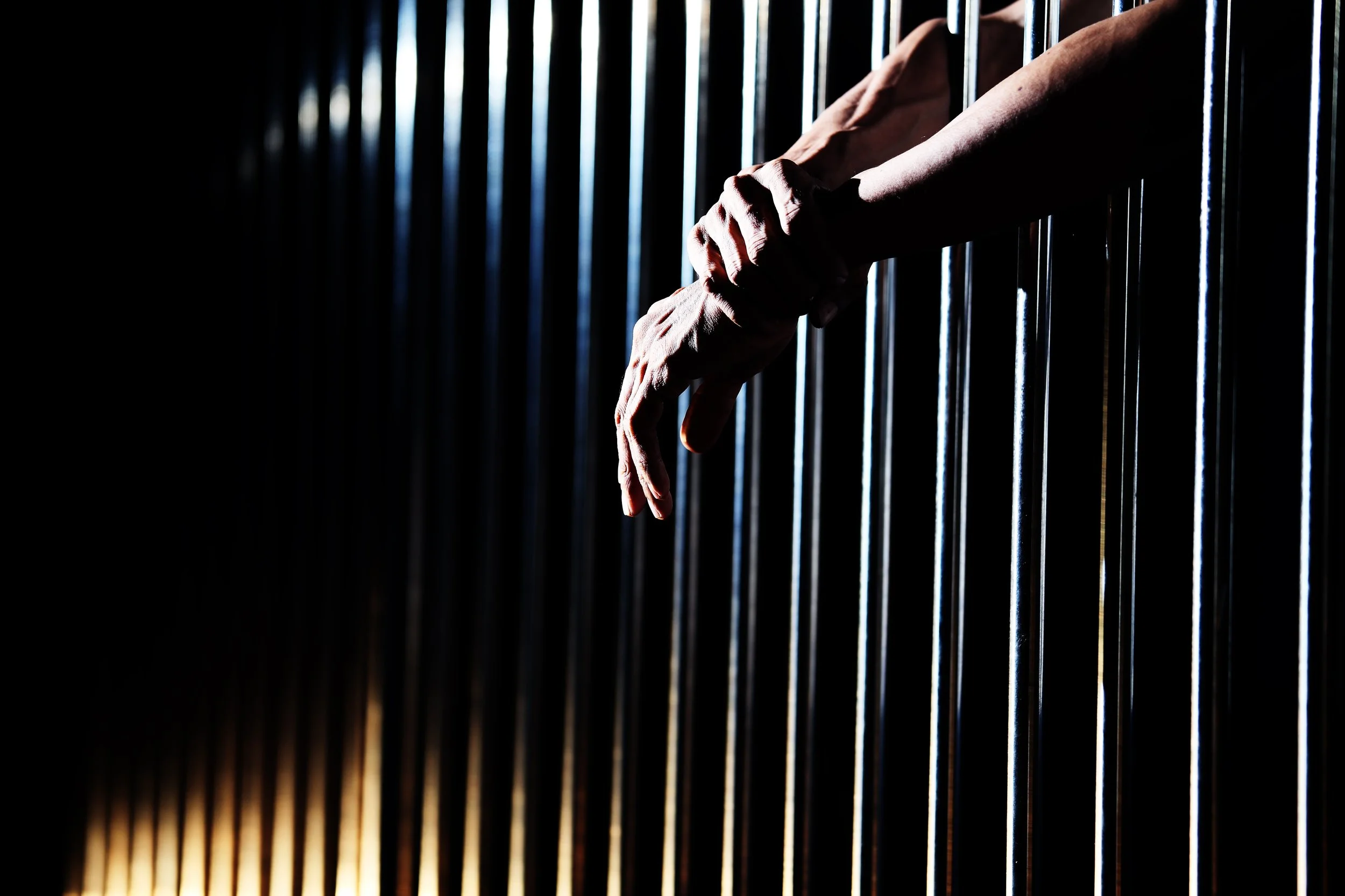 Prisoners hands in jail AdobeStock_216845226 copy.jpeg