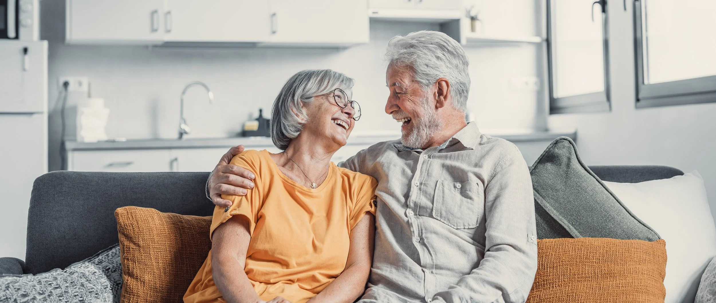 Senior man and woman sitting on lounge smiling
