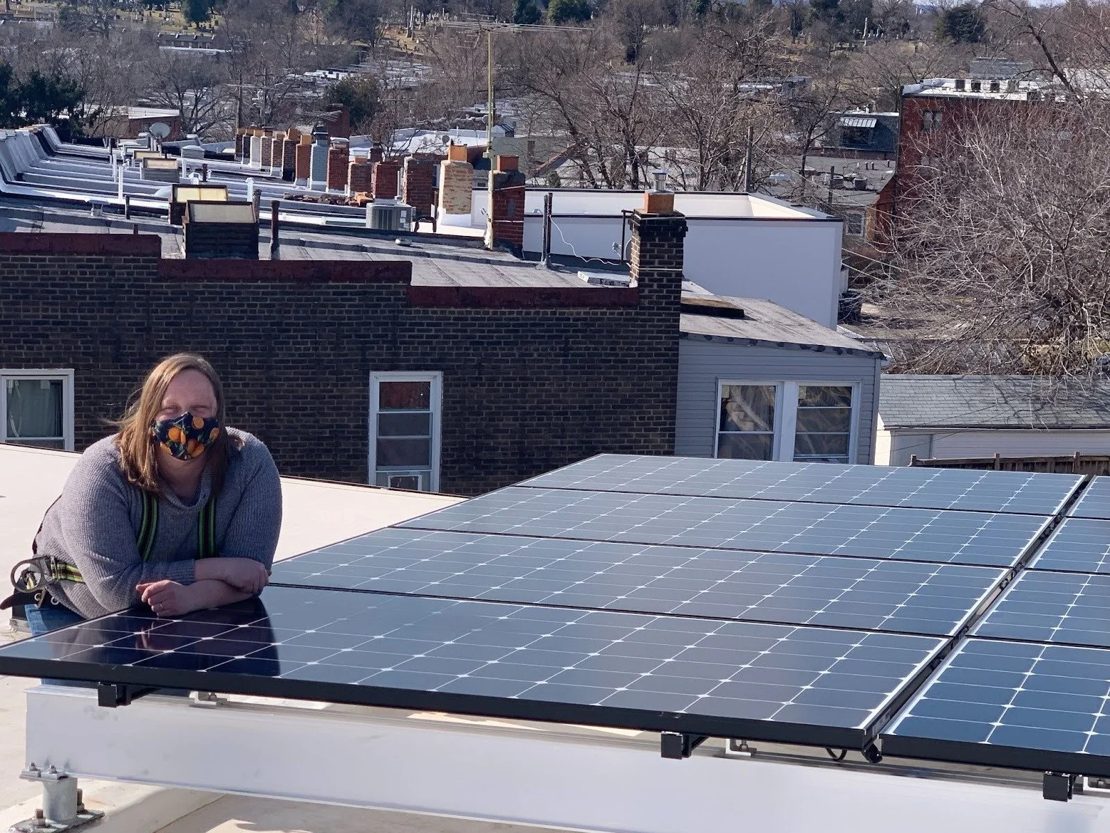 Emily on a rooftop with a solar panel install.