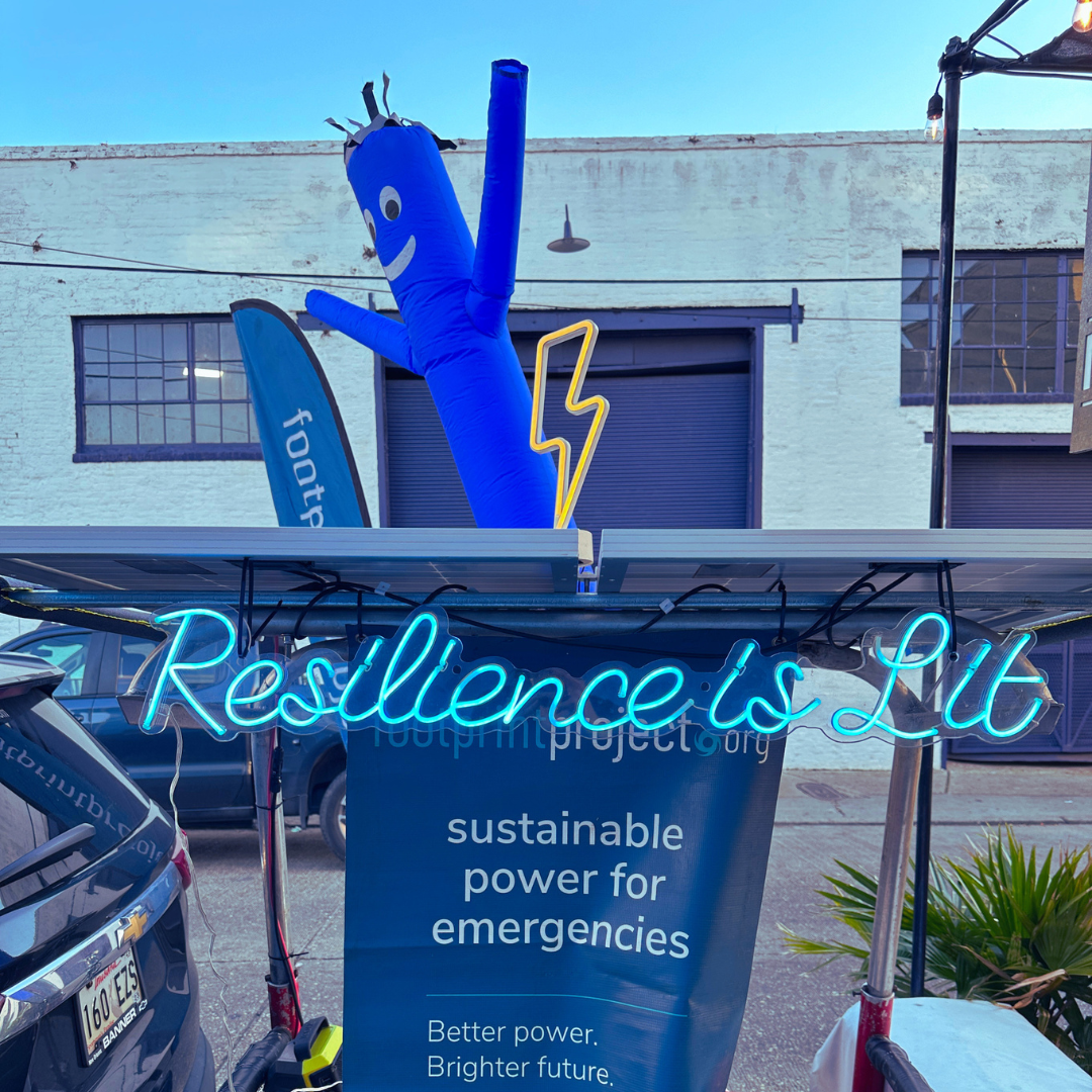 A neon sign says "Resilience is Lit" representing how power is upcycled.