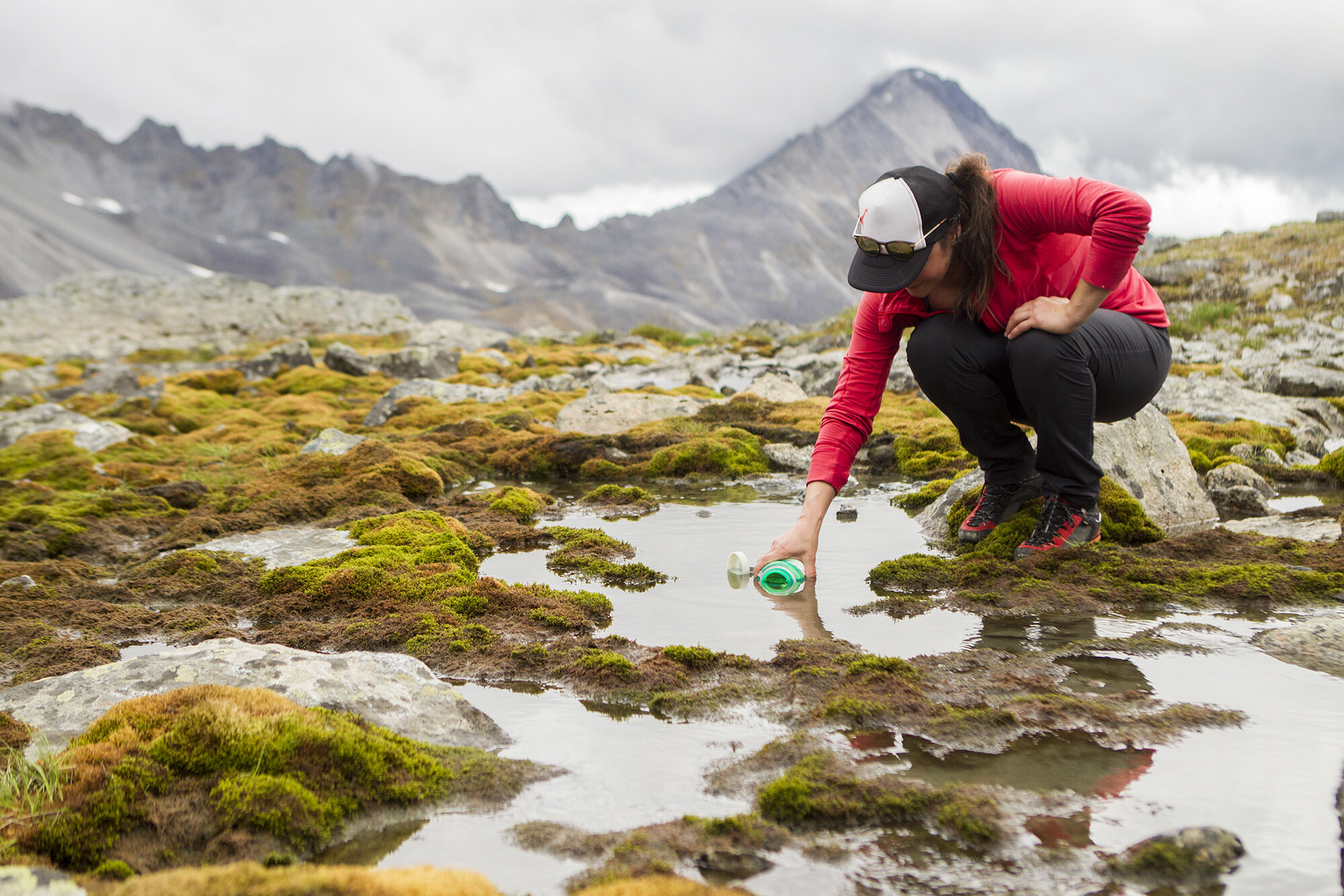 woman filtering water in the talkeetna mountains
