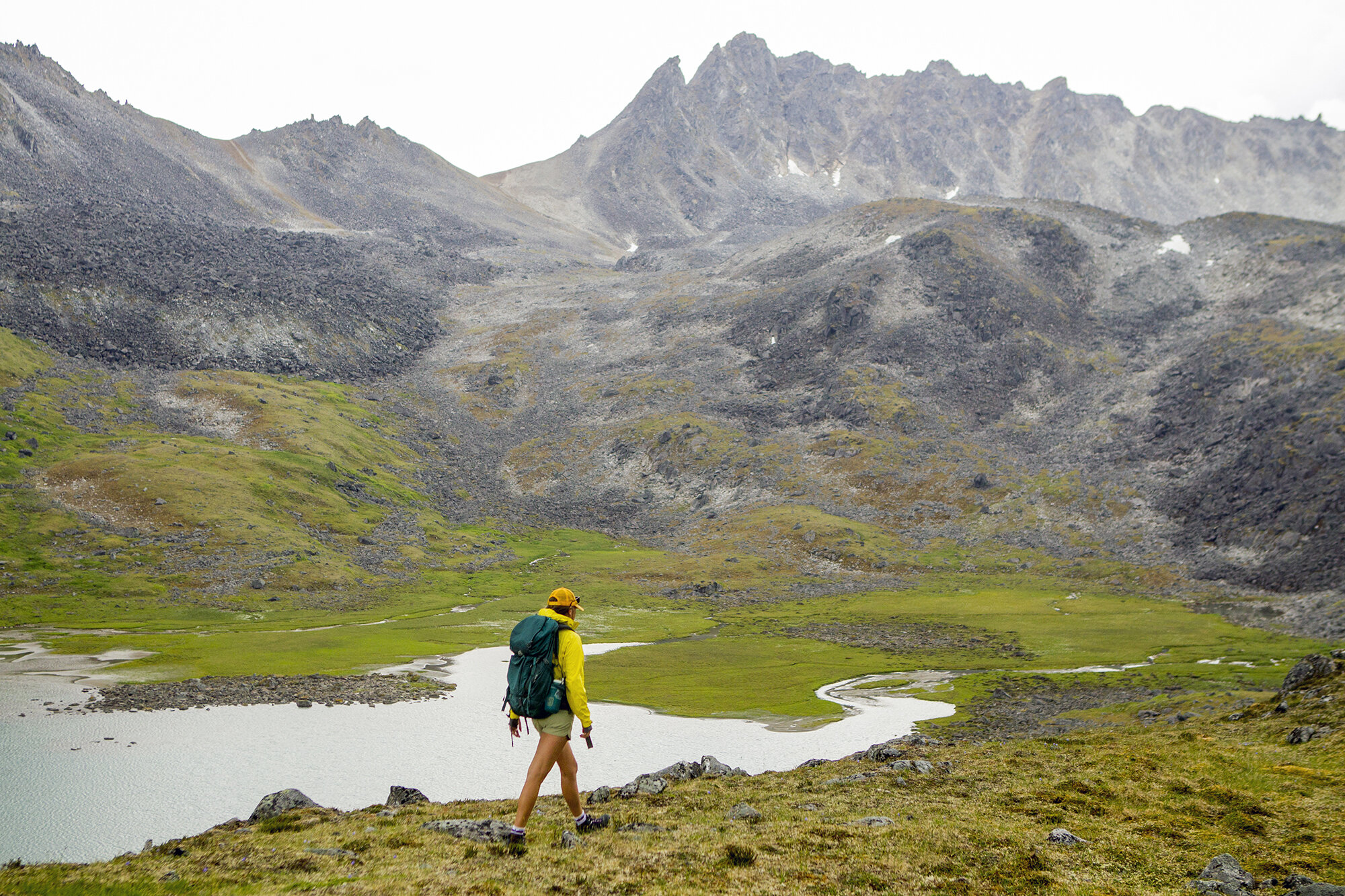 woman backpacking through alaska mountains