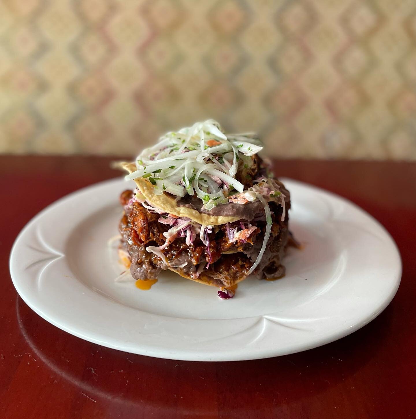 Rolos Pork tower! On special this weekend. Kansas City pulled pork with Mexican spices, Mexican slaw, pickled white onion, layered with black bean tostadas. A perfect dinner as well as sharing.