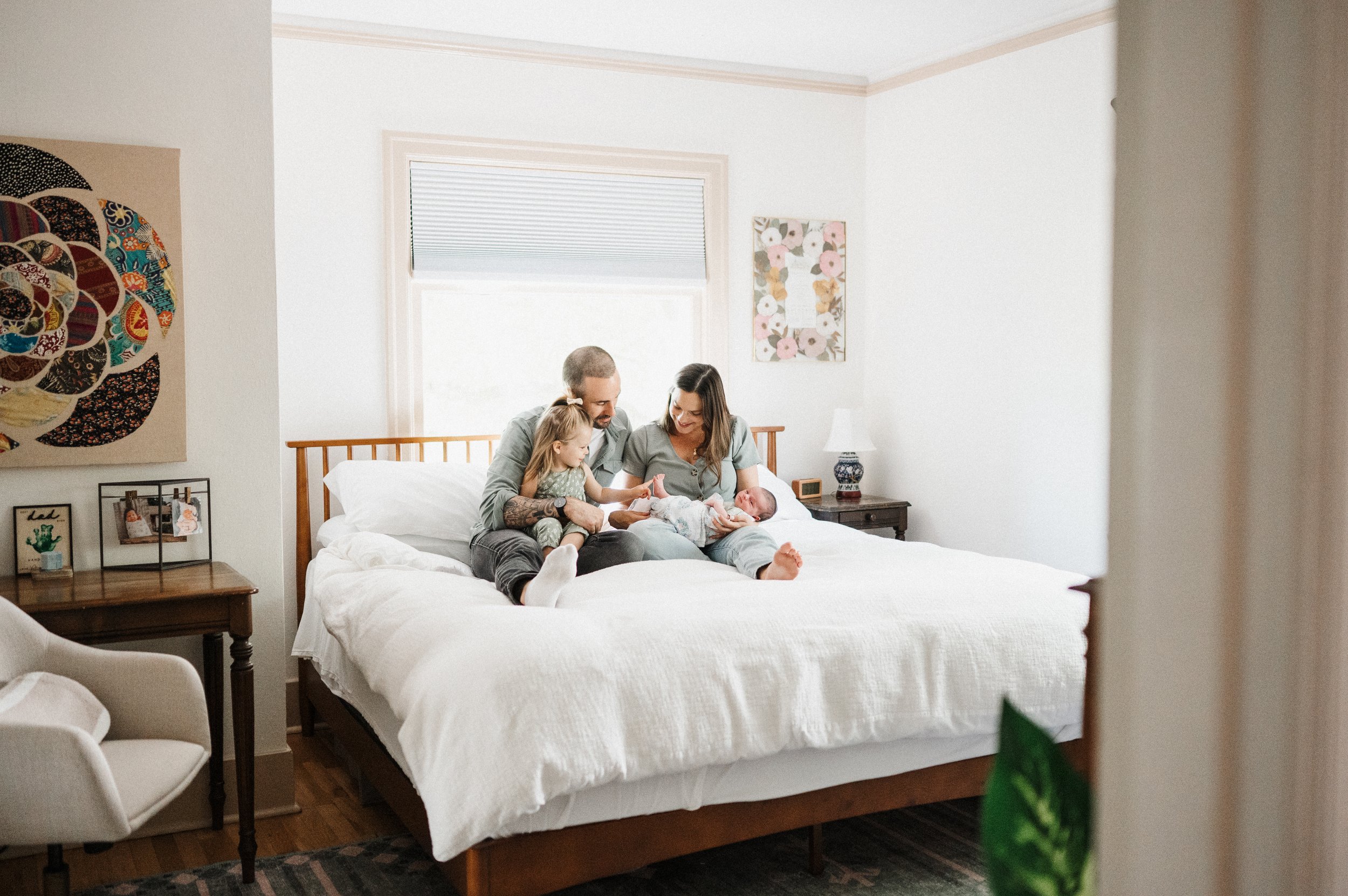 Family of four on bed during newborn photos