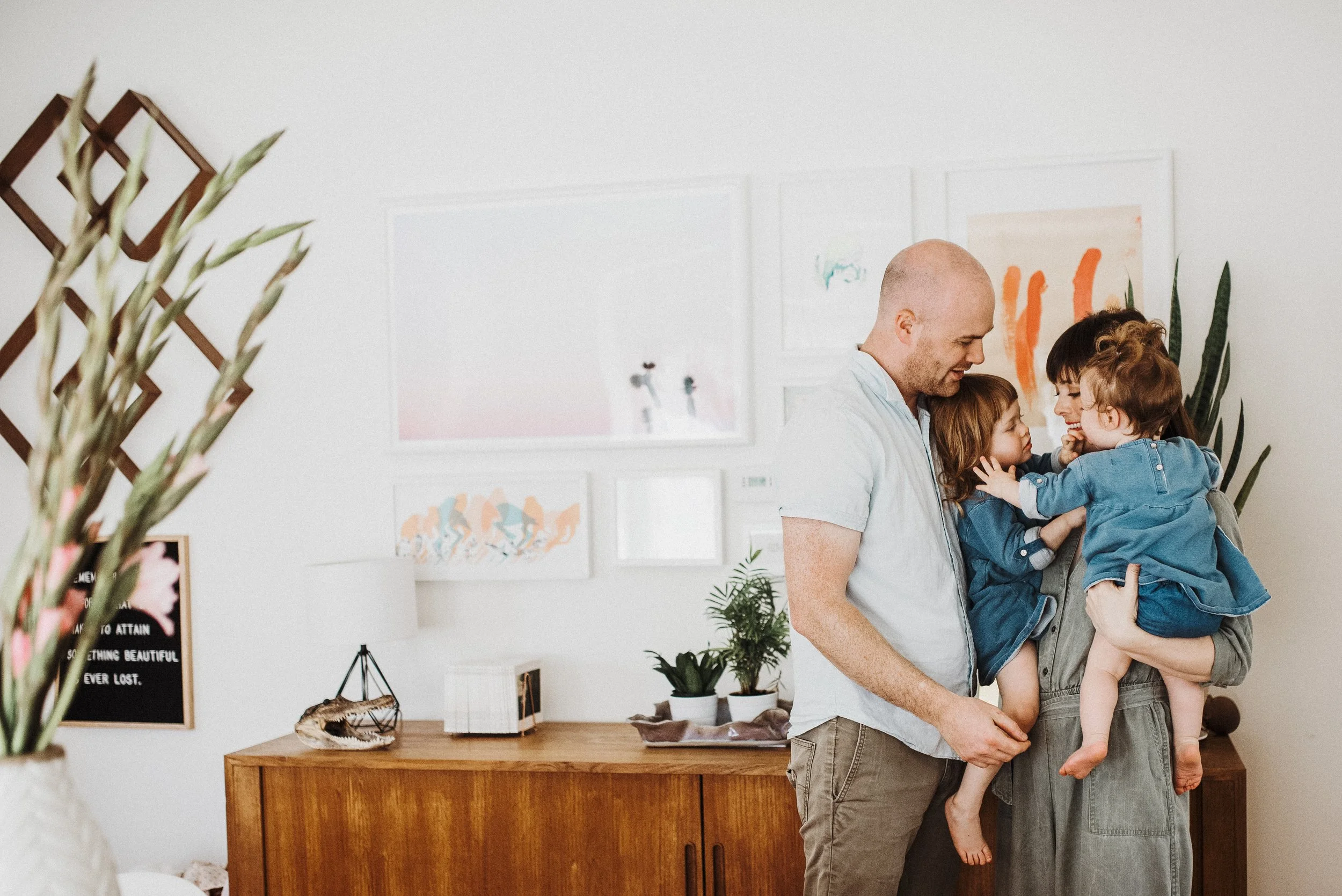 Family of four standing together in dining room