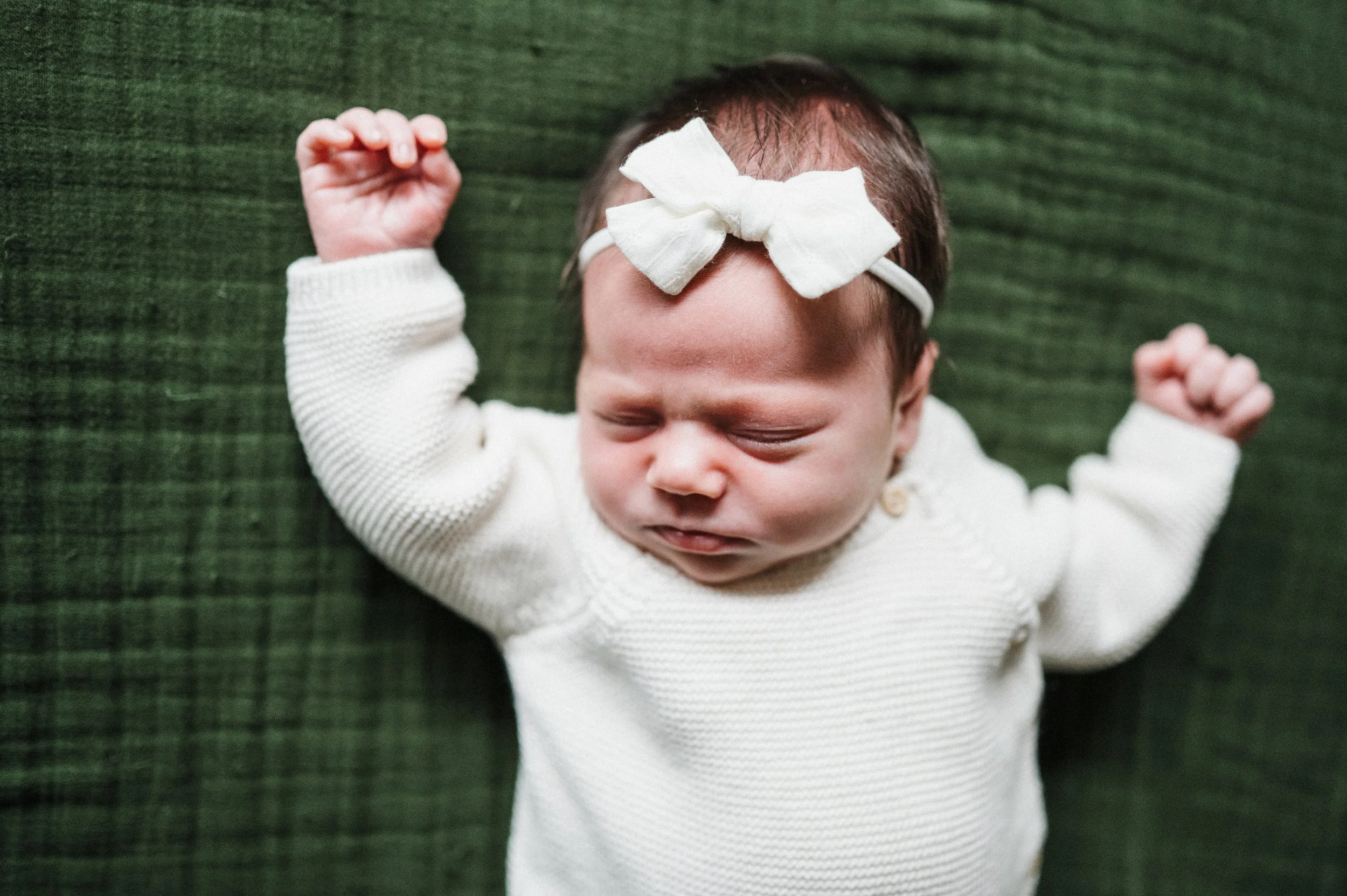 Baby sleeping on bed during newborn photography session