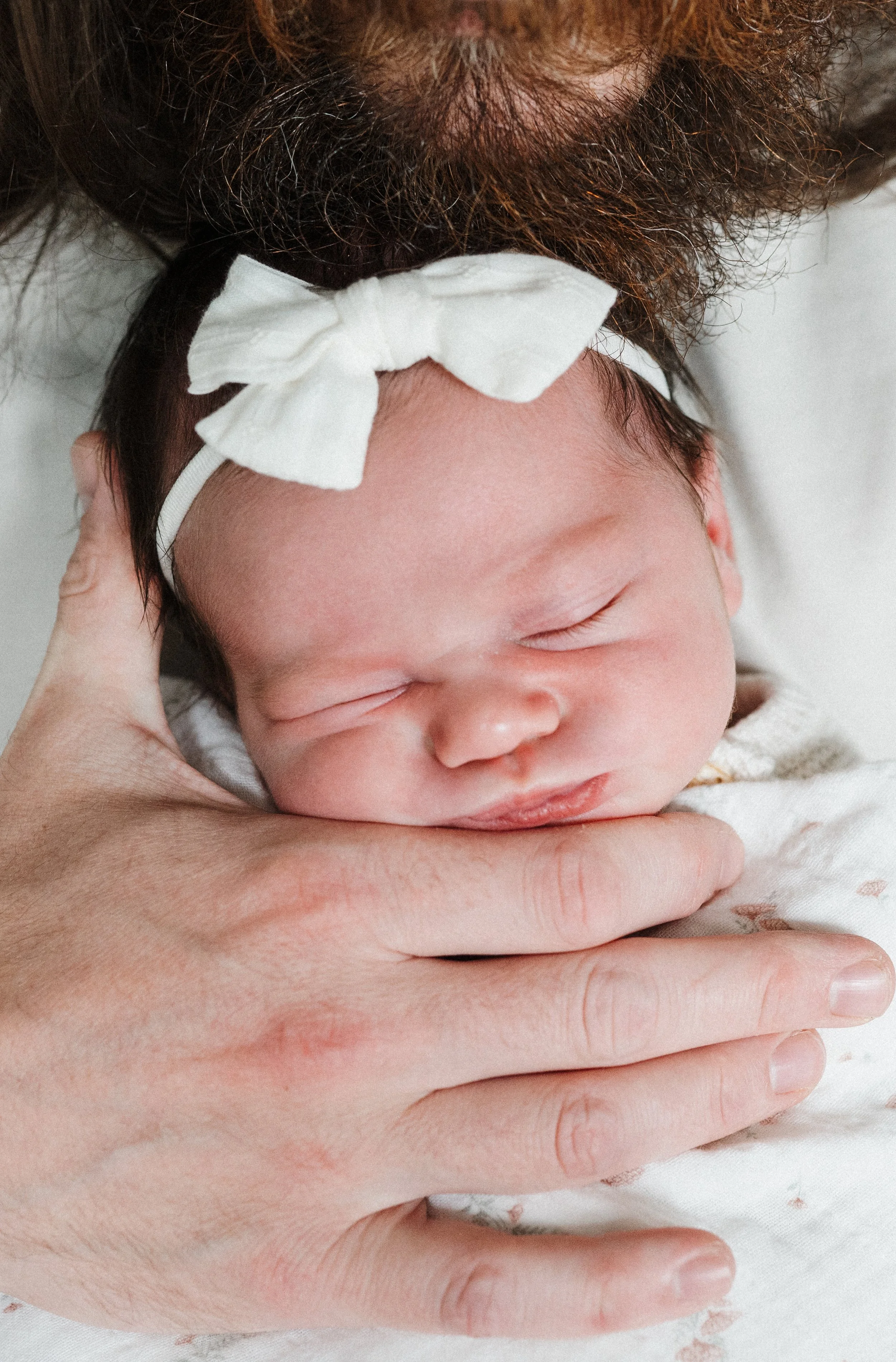 Dad holding sleeping newborn baby