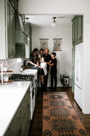 family of five standing together in kitchen