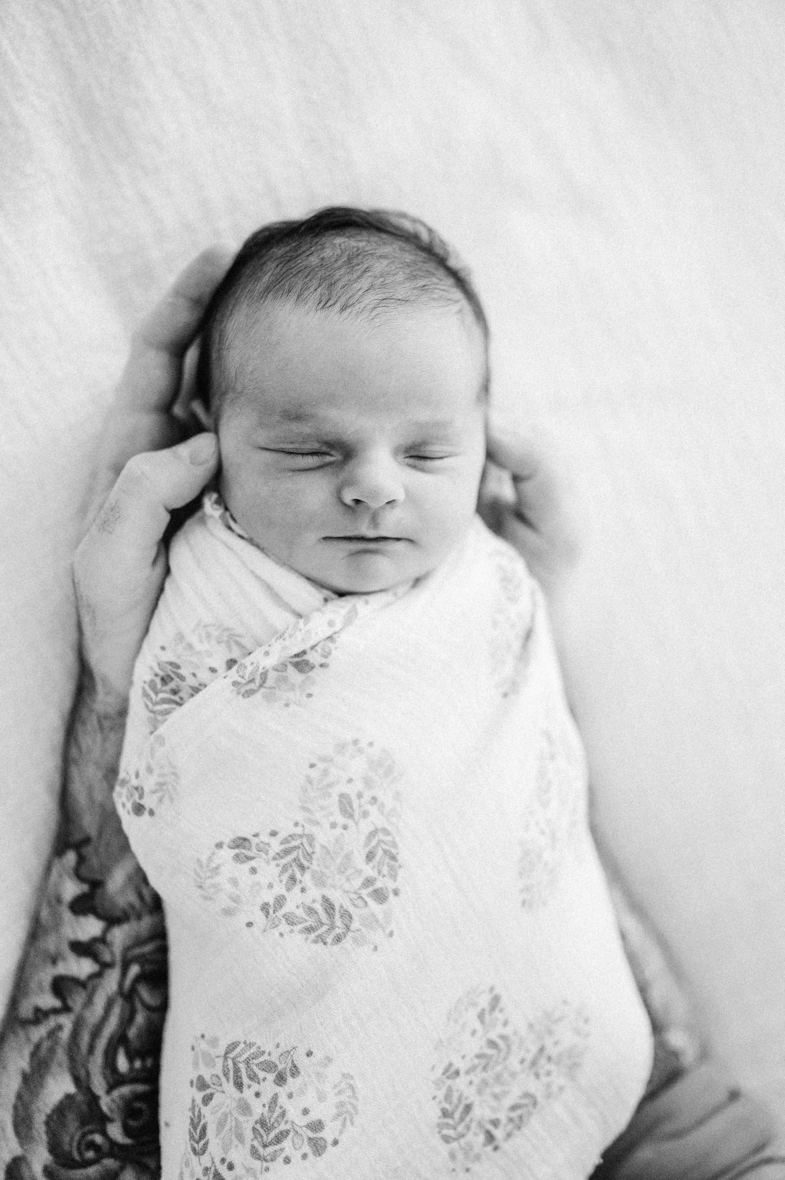 newborn baby asleep in dad's arms