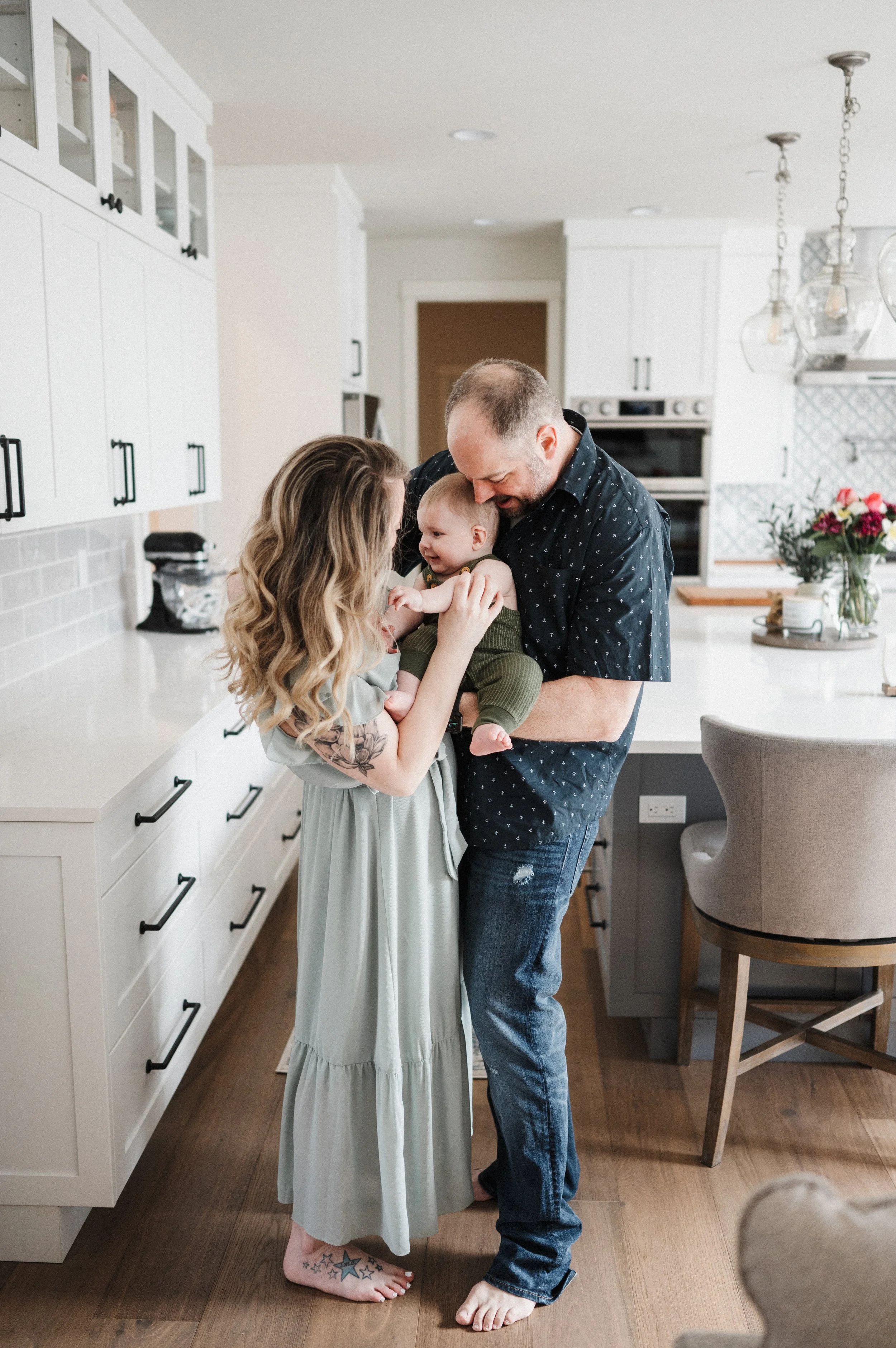 family with young boy standing together in kitchen during lifestyle photography session