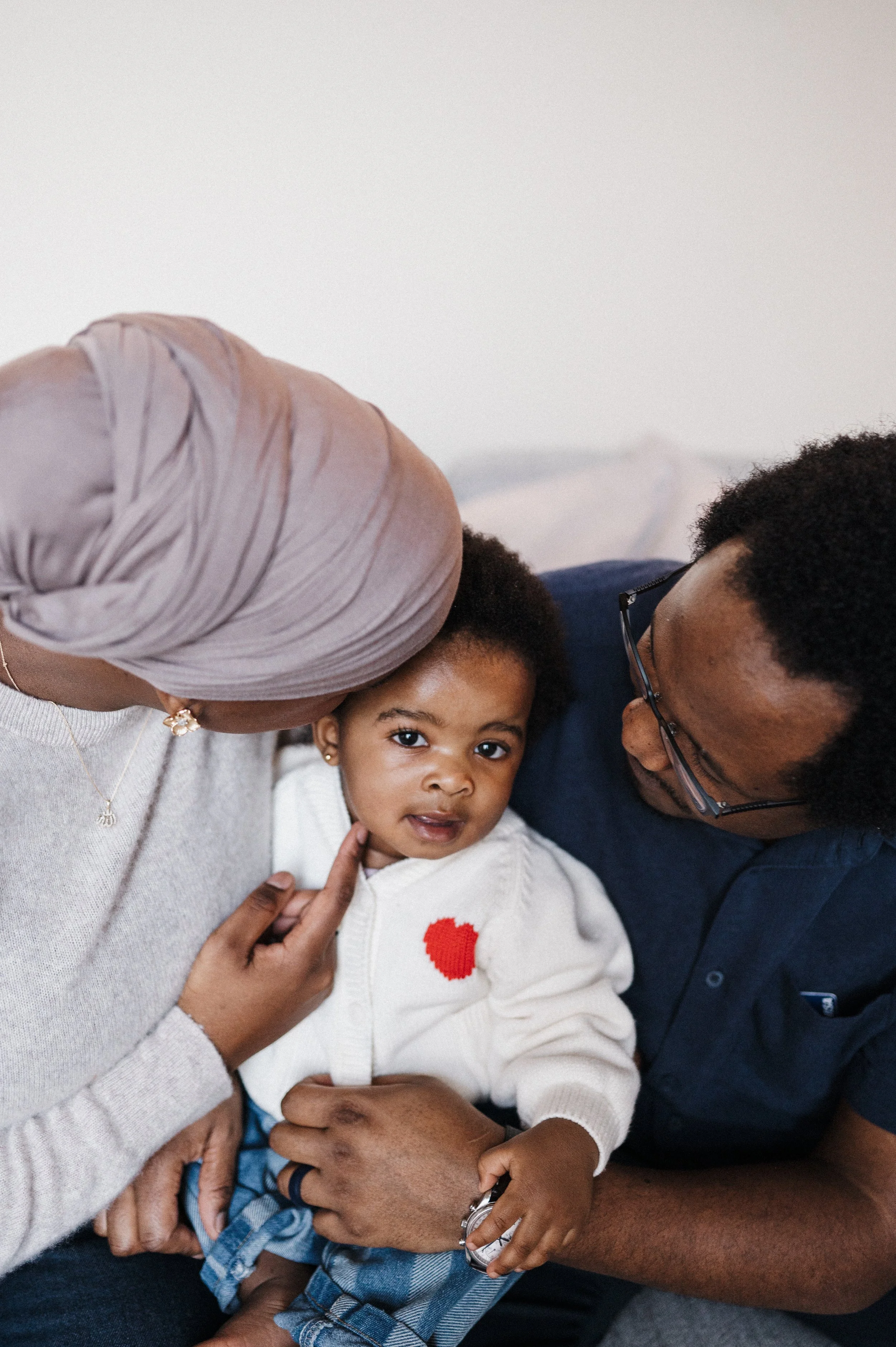 family of three sitting together during family photo session