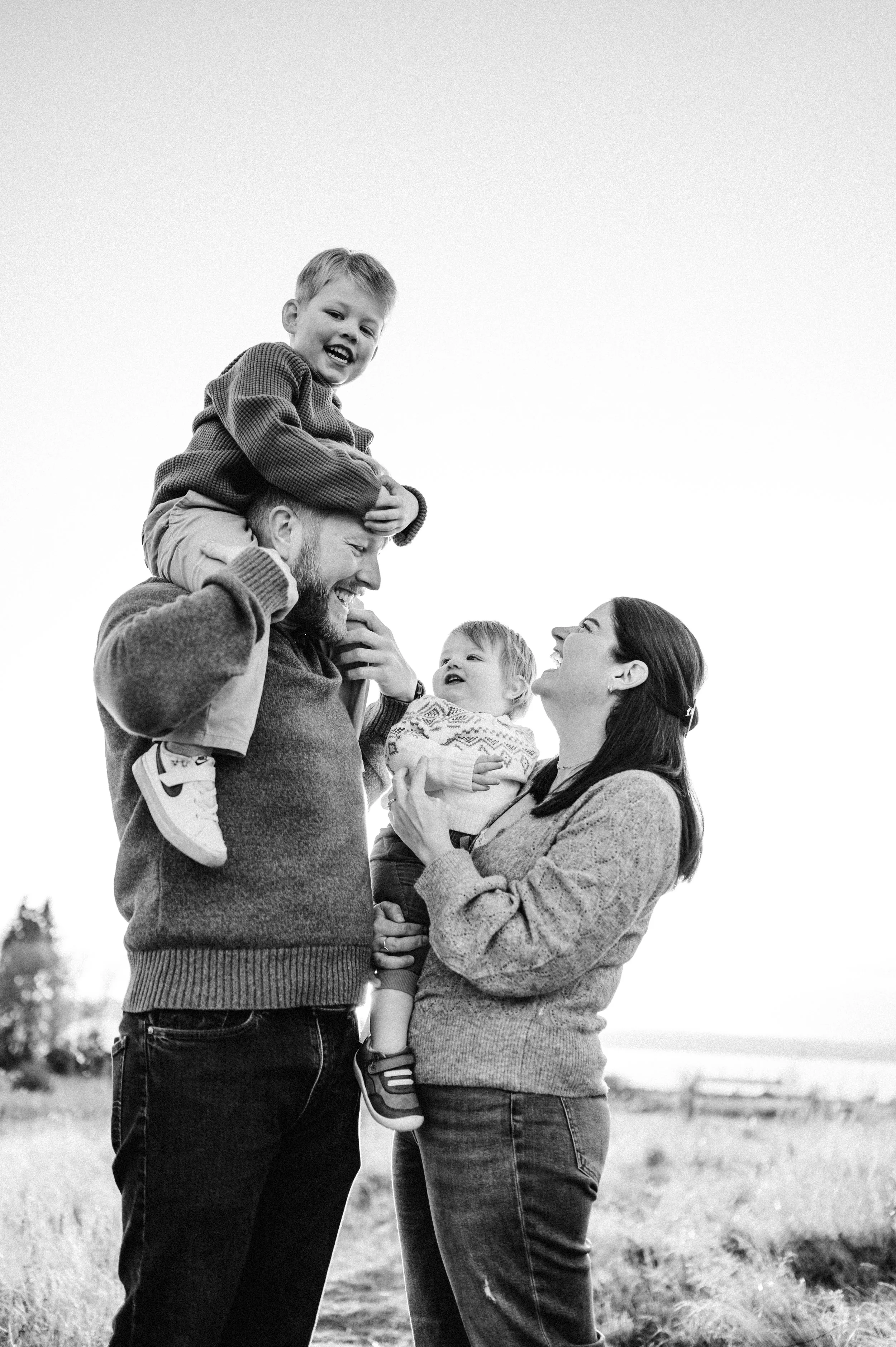 family of four with boy on dad's shoulders