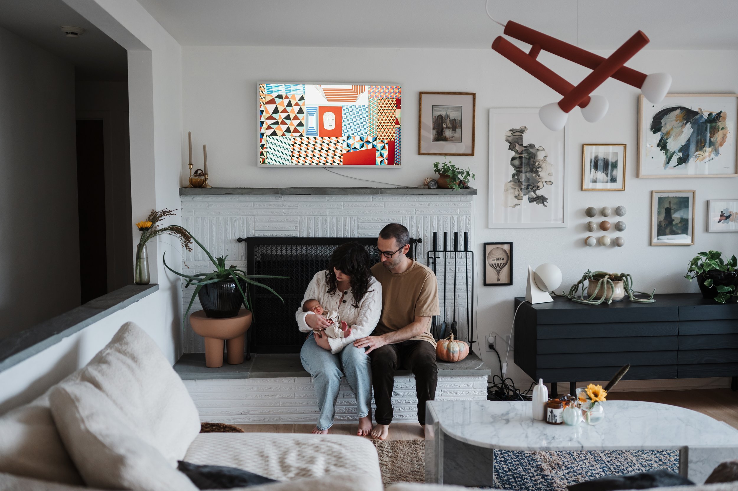 Parents holding newborn baby in living room