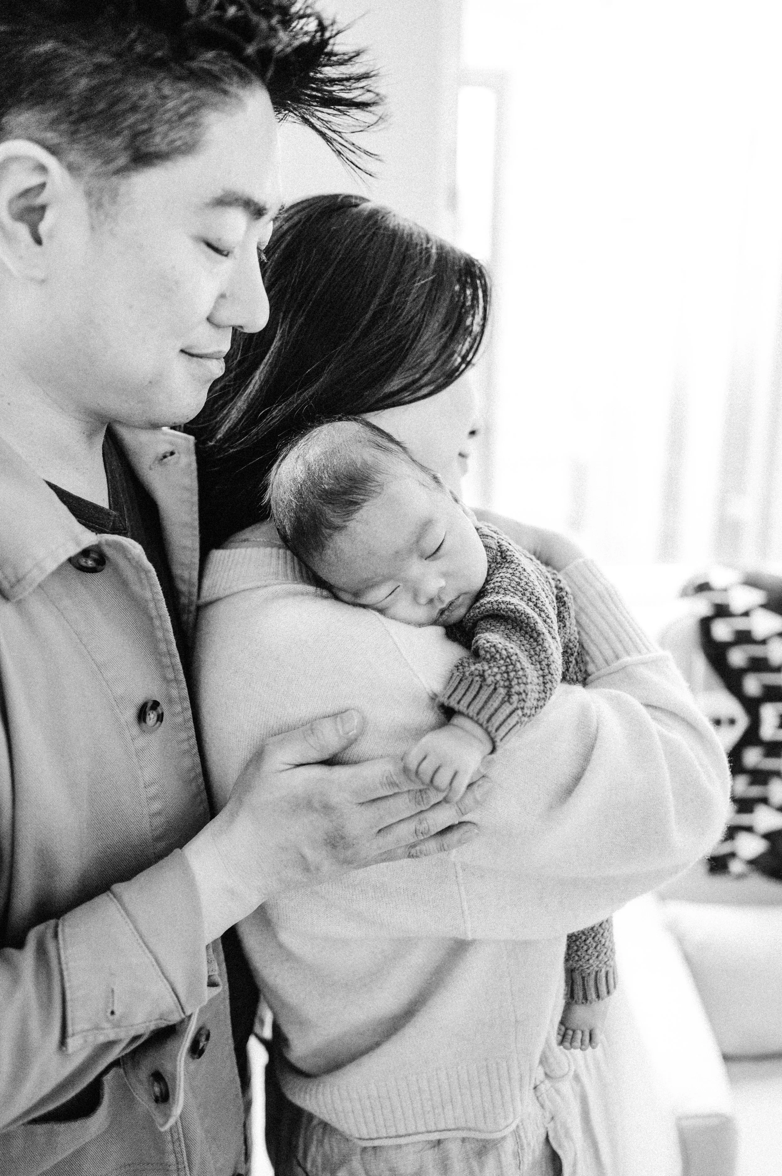 Mom and dad standing with sleeping baby
