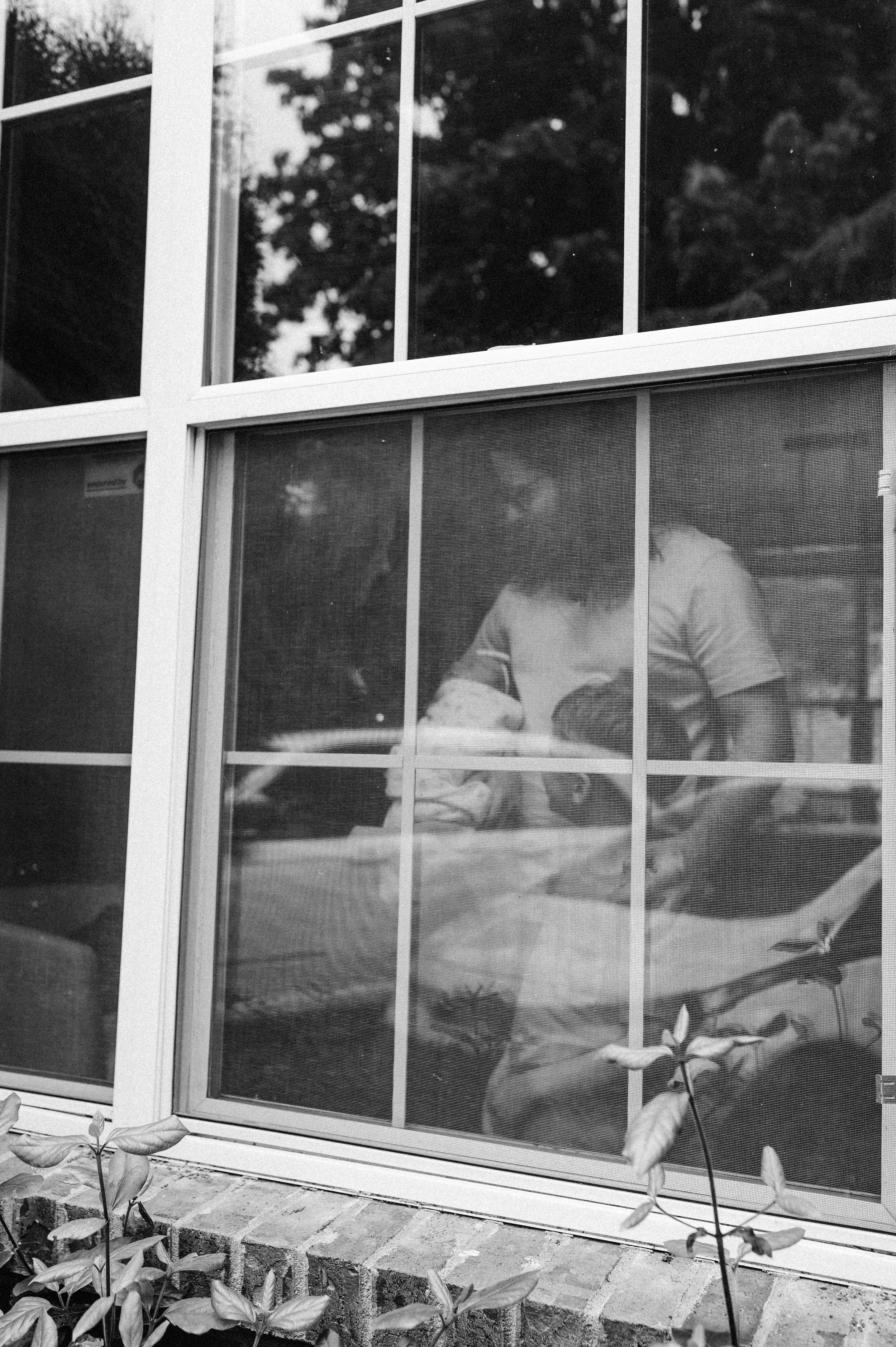 family poses in window with newborn