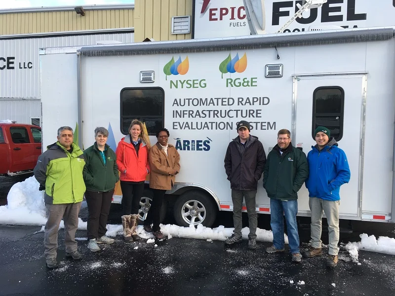 The team stands in front of the ARIES I trailer, stationed at Danbury Municipal Airport, Executive Air Services (FBO). (l-r) Marco Antonio Mendez Gonzalez, Inmaculada Sanz Santidrian, Nuria Cortes Moradell, La Wanda Ervin, Kevin Cox, Tom Evans, and Jakshylyk Urmatbek.