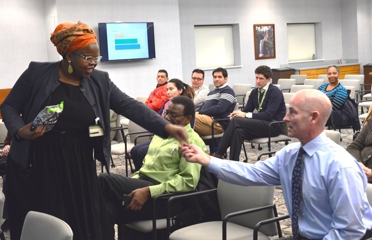 Professor Danielle Ponder gives RG&E's Greg George a piece of chocolate for volunteering to ask a question at the presentation.