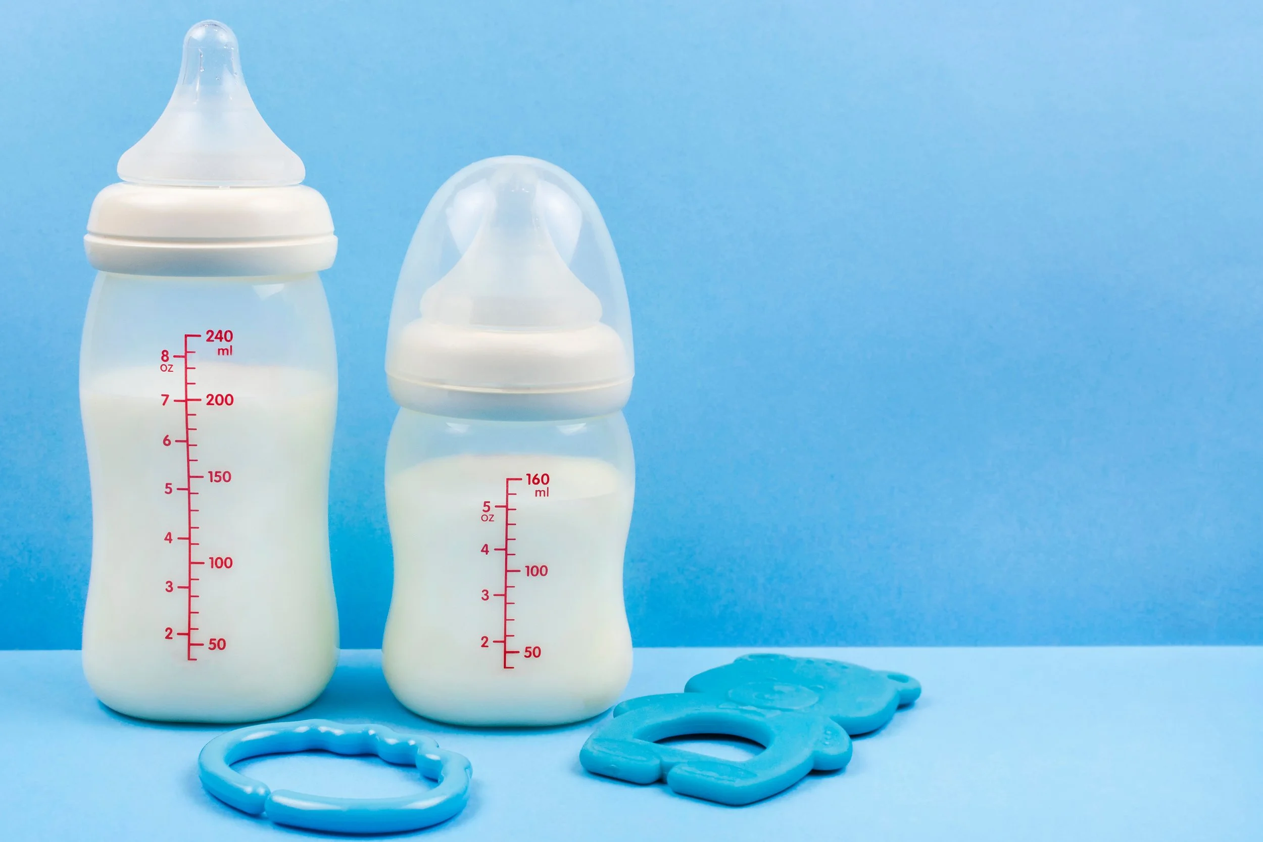 Two baby bottles with toys