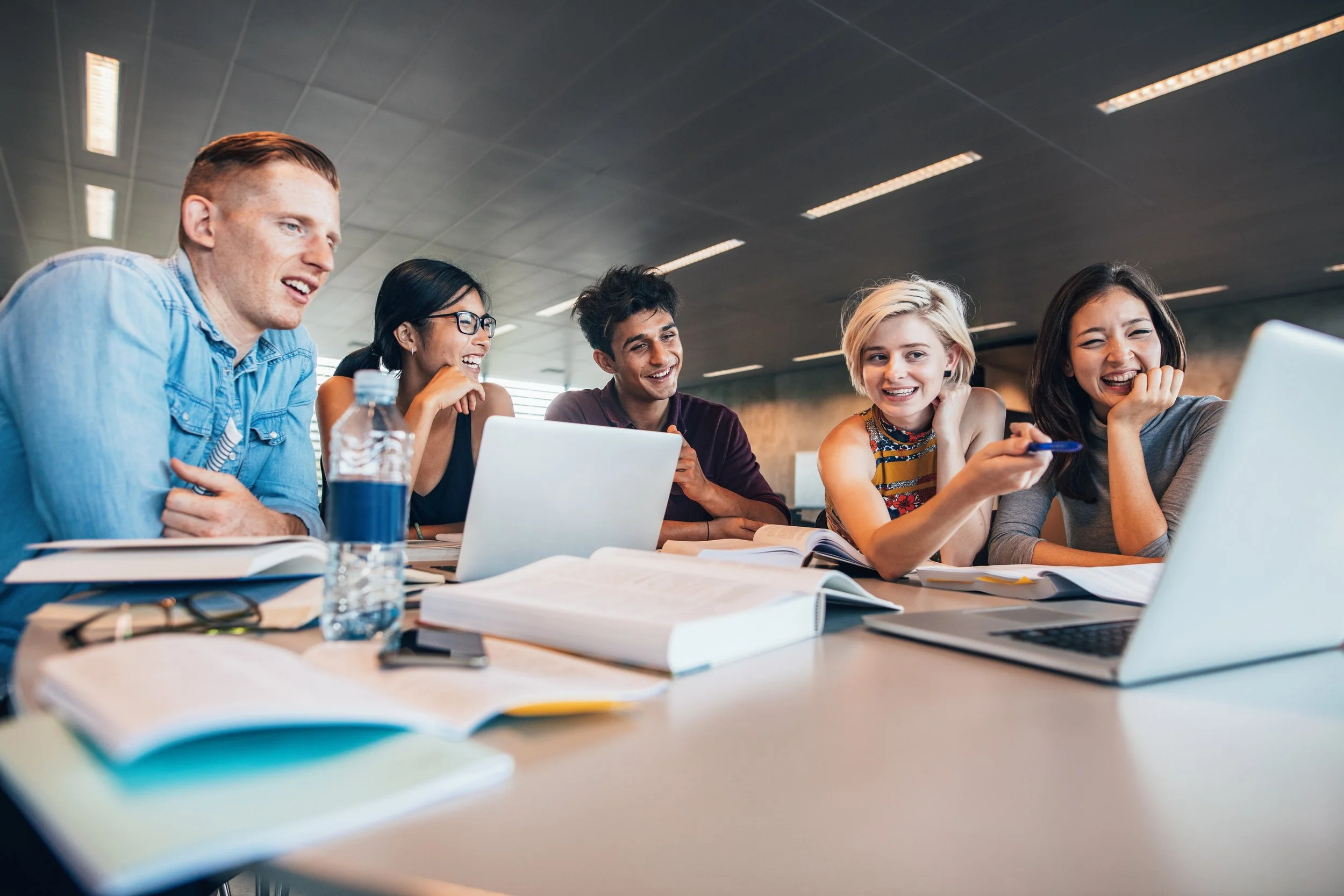 University students sitting at table and looking at the same computer