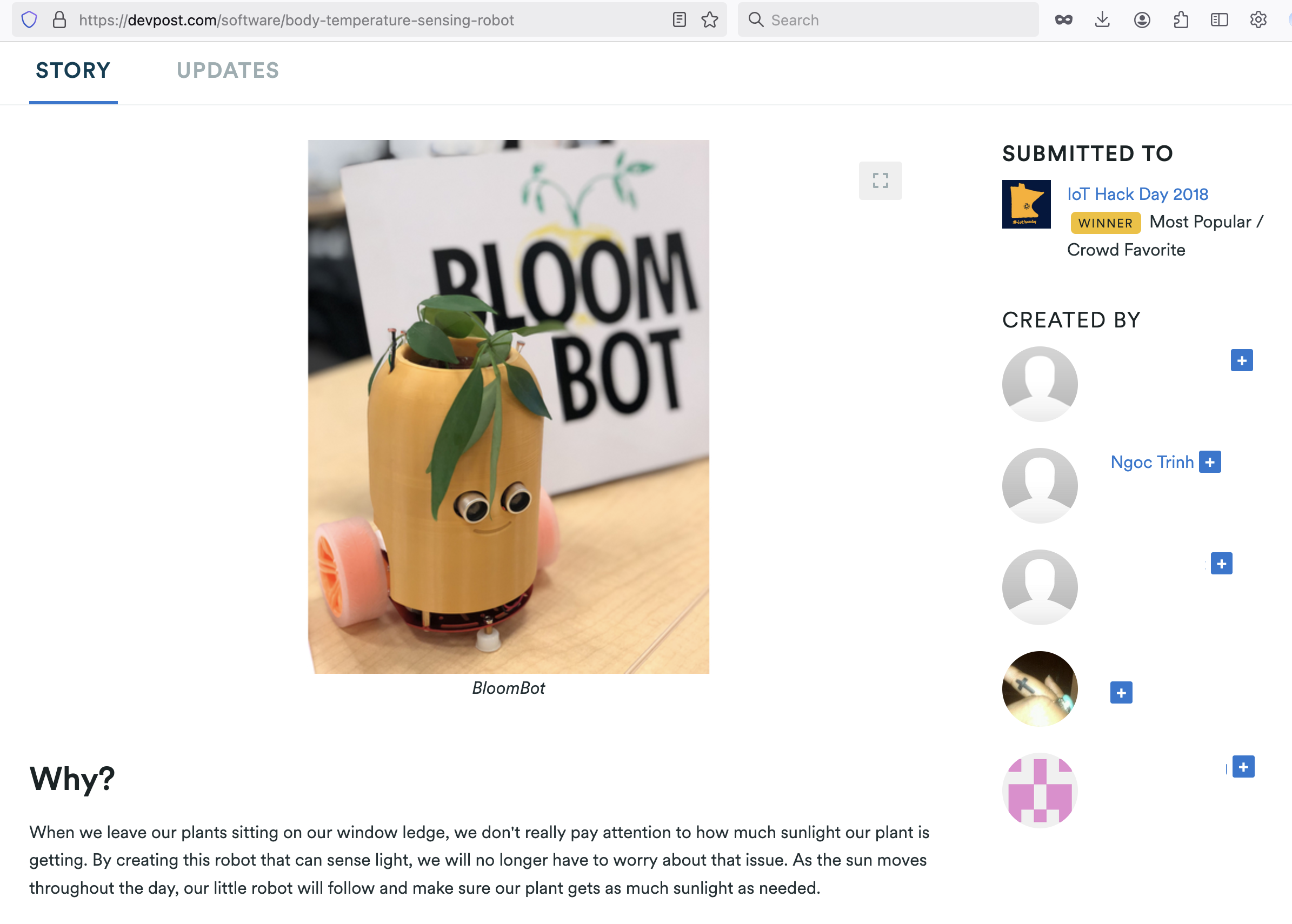 A small robot made from yellow and orange plastic and a recycled paper tube, with googly eyes, leaves on top, and pink wheels, in front of a sign that says "BLOOM BOT".