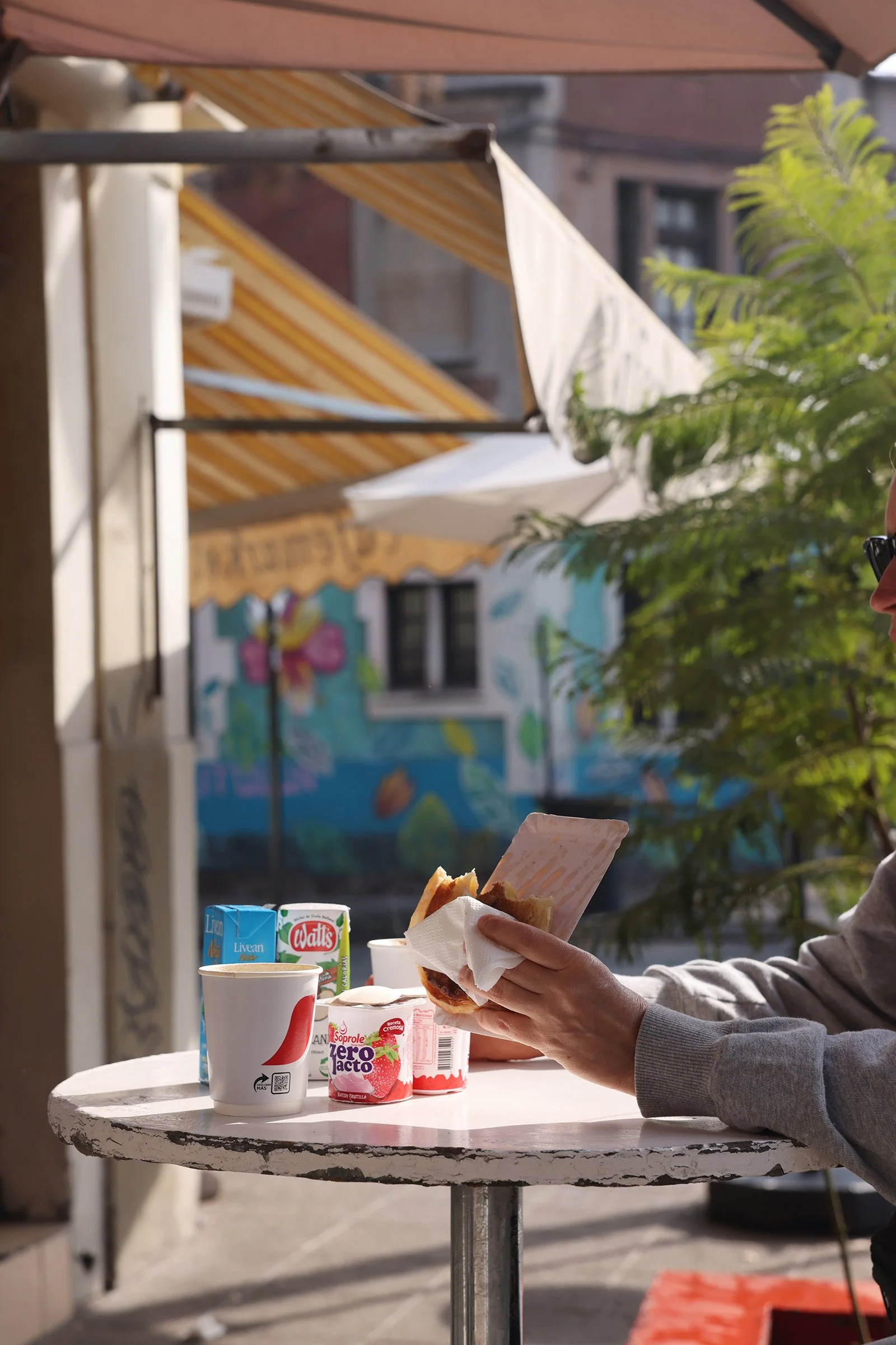 Frukost vid ett runt bord i ett soligt gatuhörn i Santiago de Chile