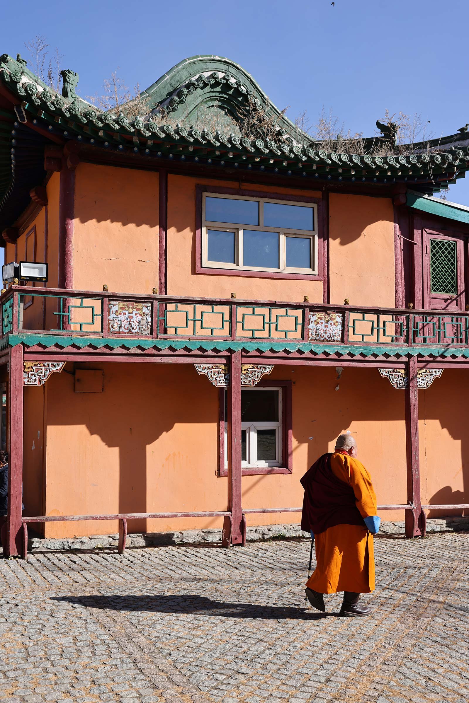  En munk i orange dräkt vid Gandantegchinlen-klostret, ett buddhistiskt kloster i Ulaanbaatar, Mongoliet 