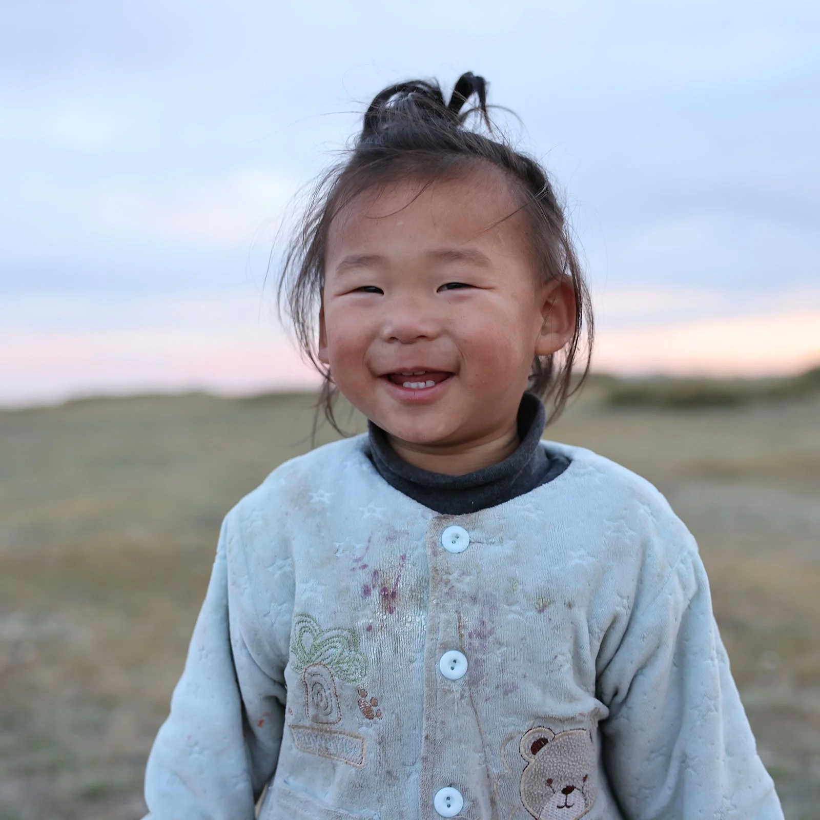  Leende flicka ute på stäppen i Mongoliet 