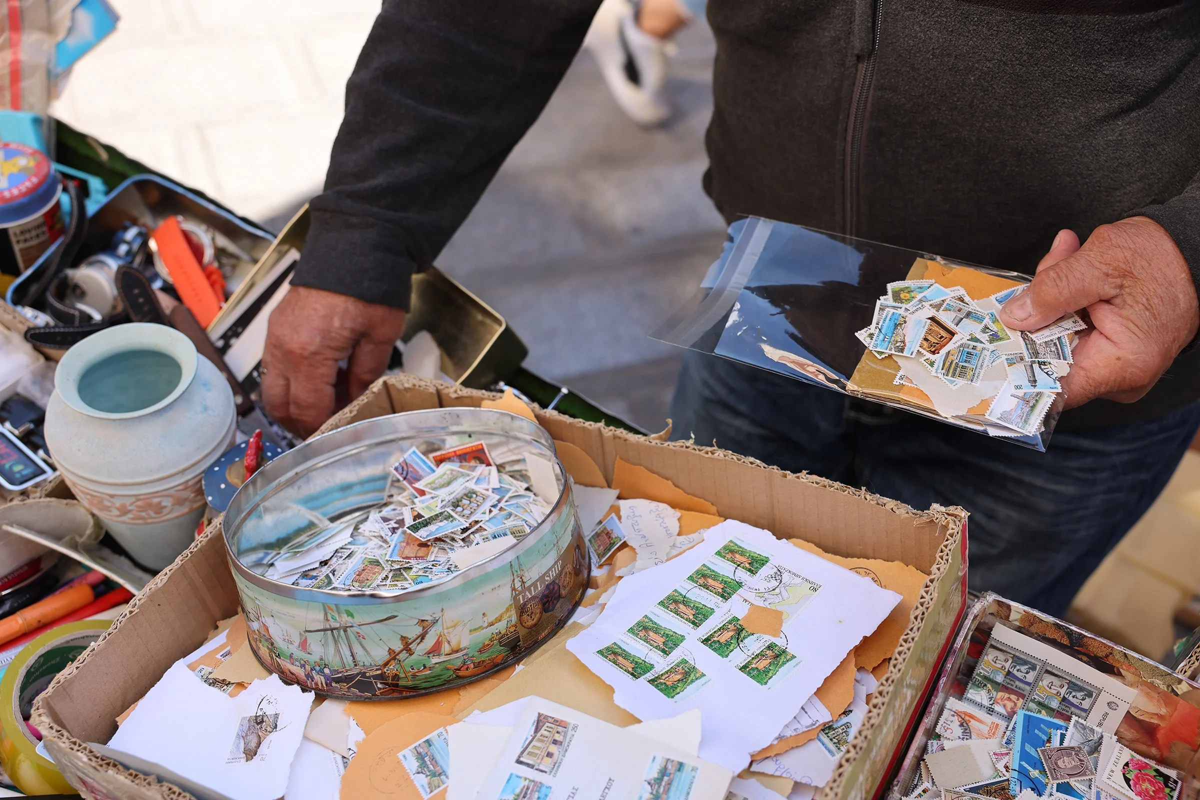 En man säljer frimärken på torget Monastiraki i Aten, Grekland