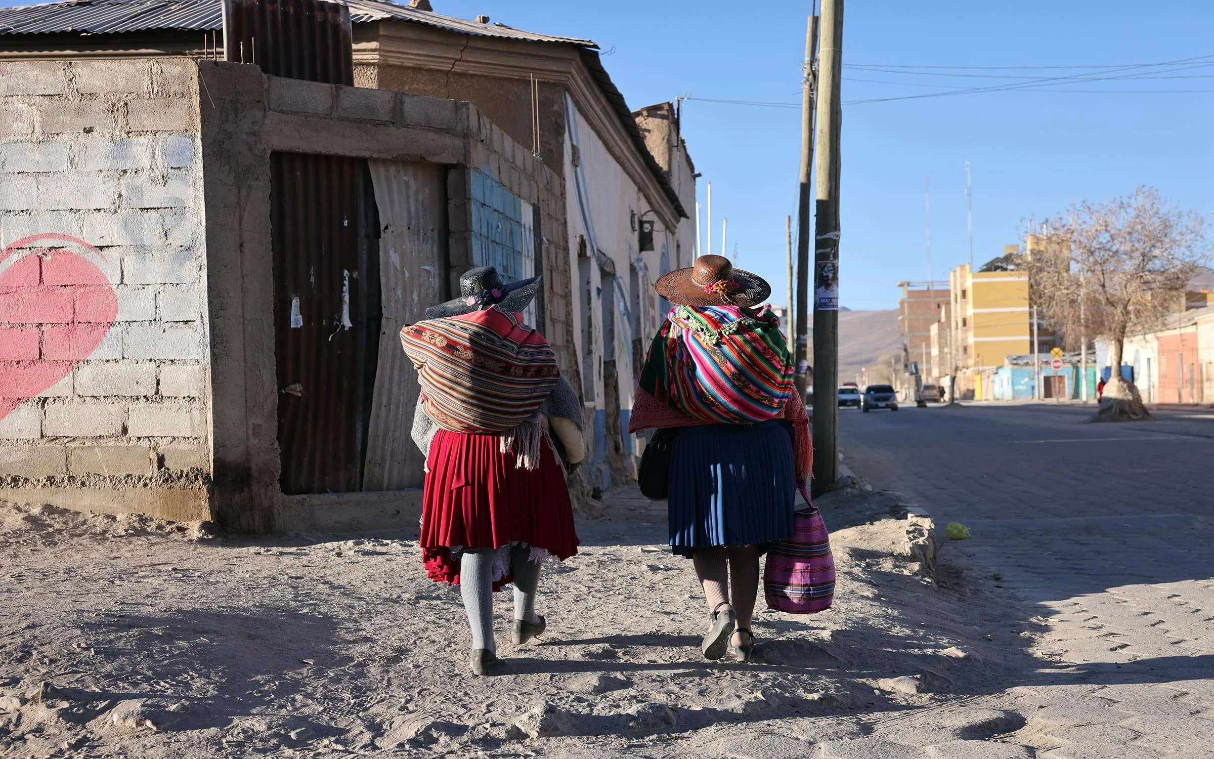 Två kvinnor i traditionella kläder på en väg i Uyuni, Bolivia