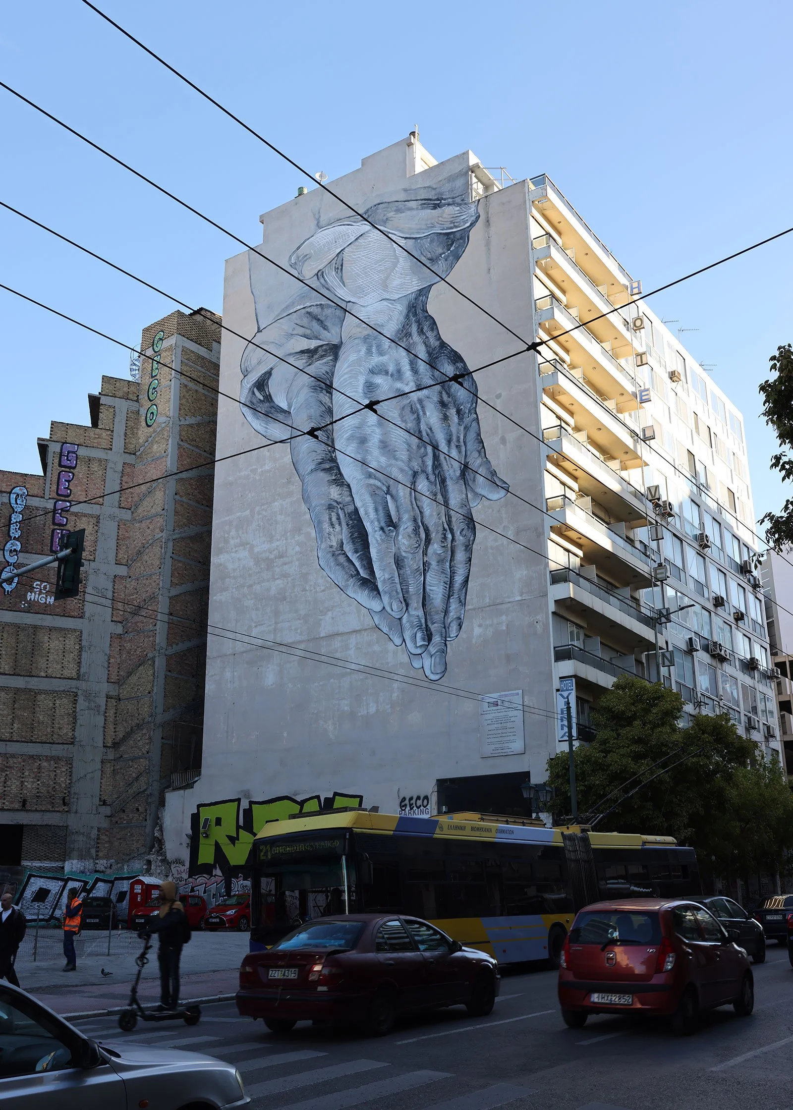 Streetart i form av två händer på en husfasad – Hands av Pavlos Tsakonas – i Aten, Grekland