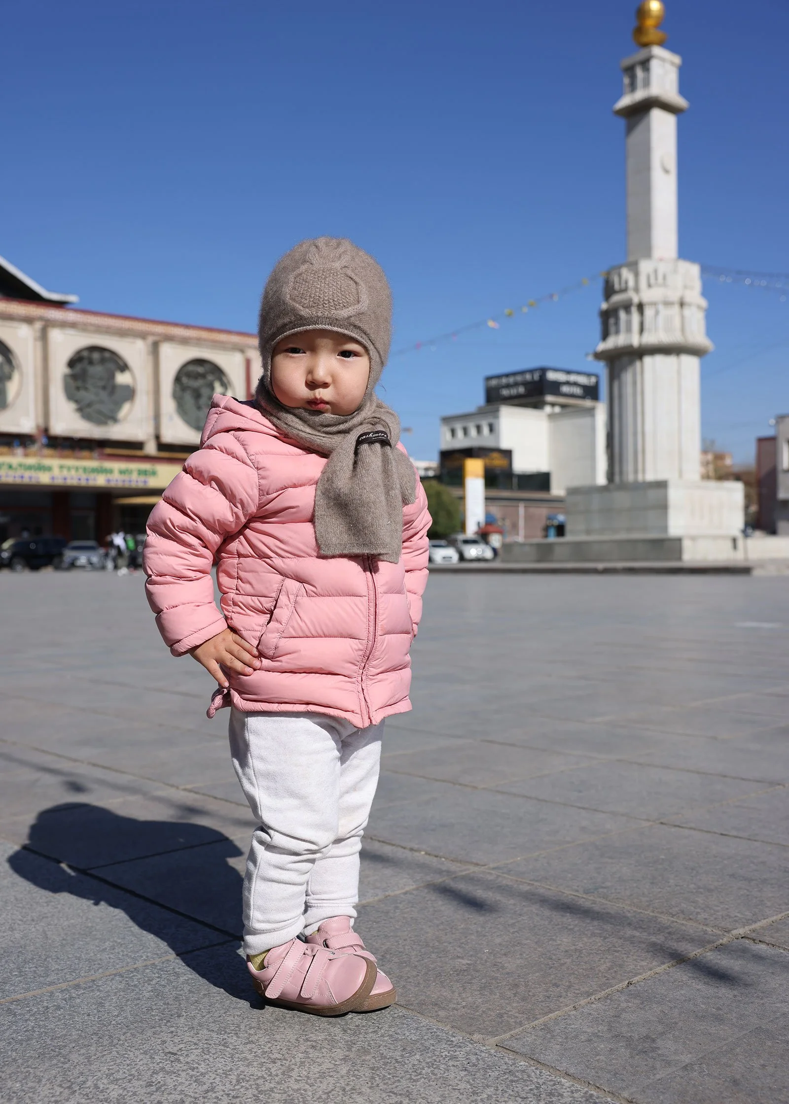 Mongolisk flicka i ljusrosa jacka framför Natural History Museum of Mongolia i Ulaanbaatar, Mongoliet