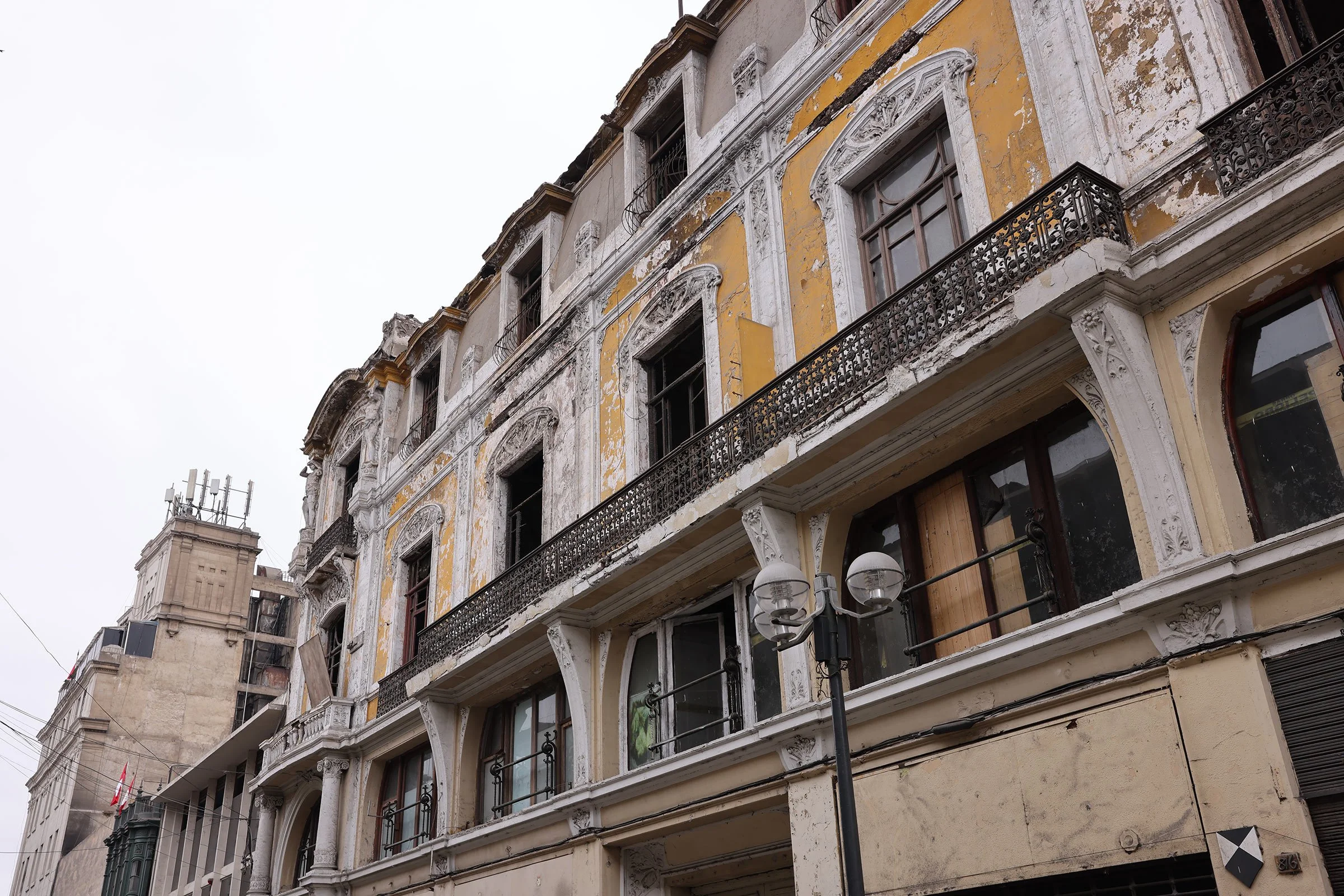 En sliten äldre husfasad till en vacker byggnad i Limas historiska centrum, Peru
